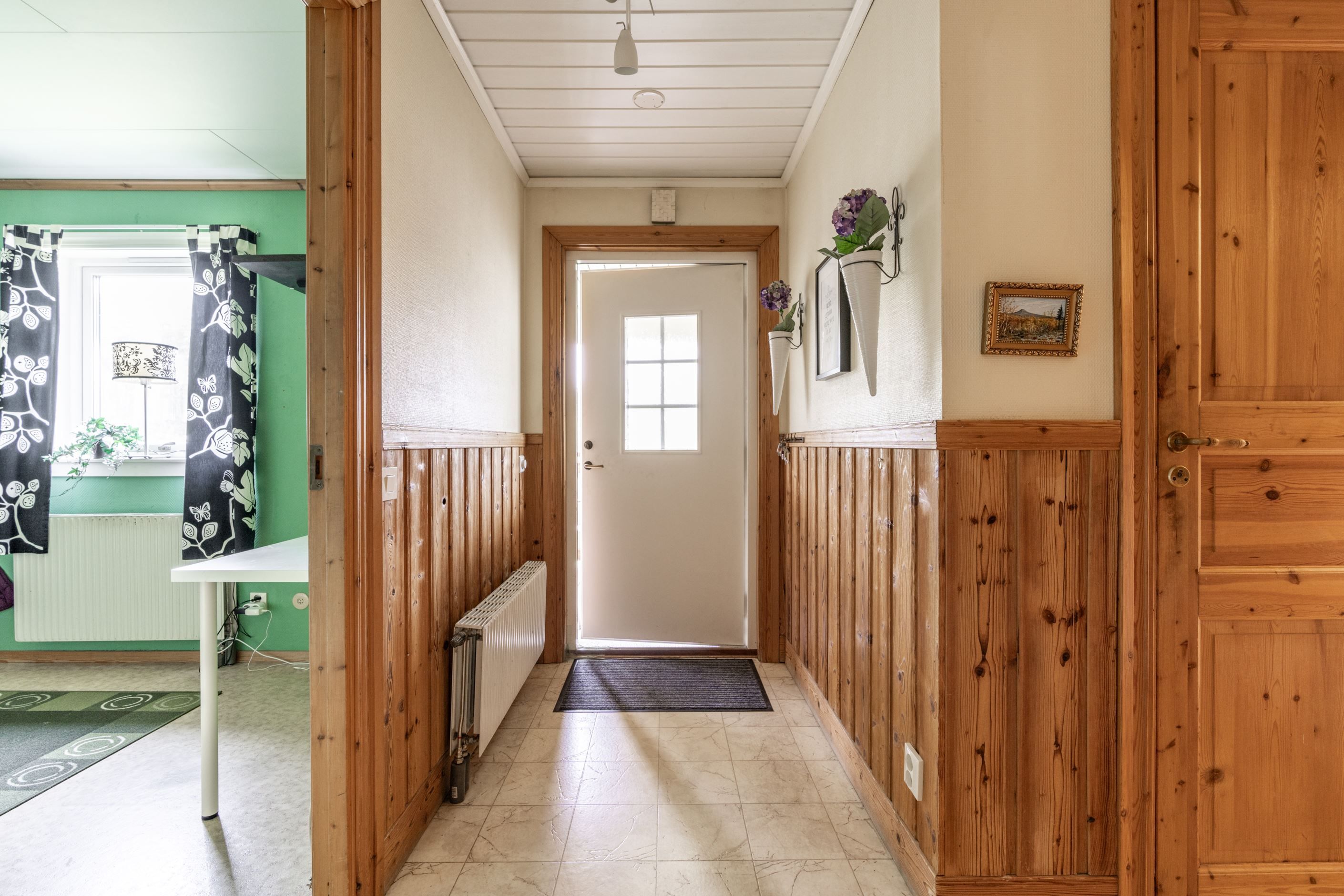 Hall med sovrum 1 till vänster i bild och dörr till badrum till höger