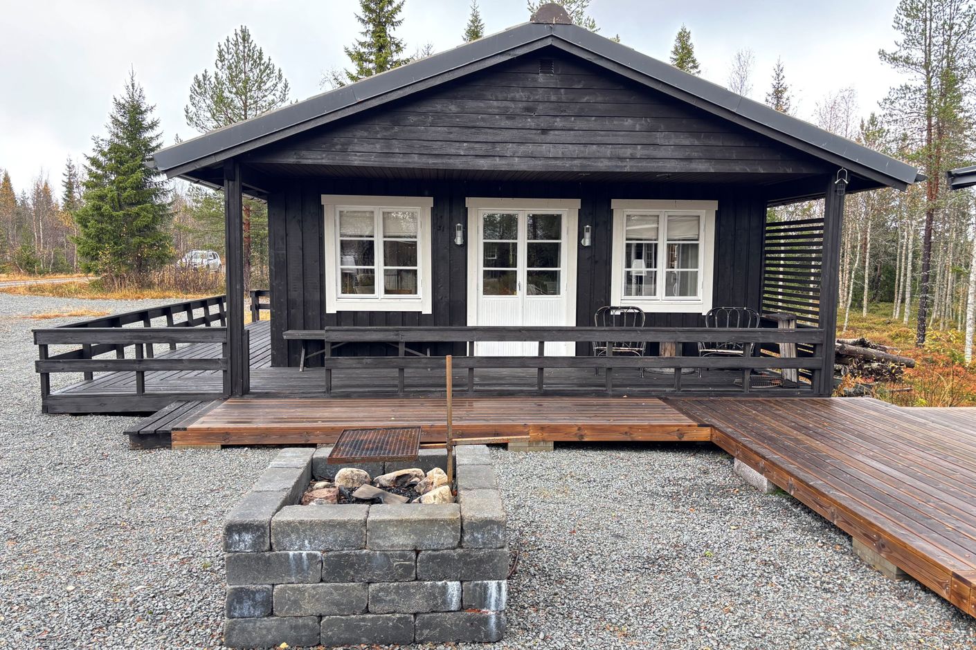 Huset med ute eldstad och altangolv mellan byggnaderna