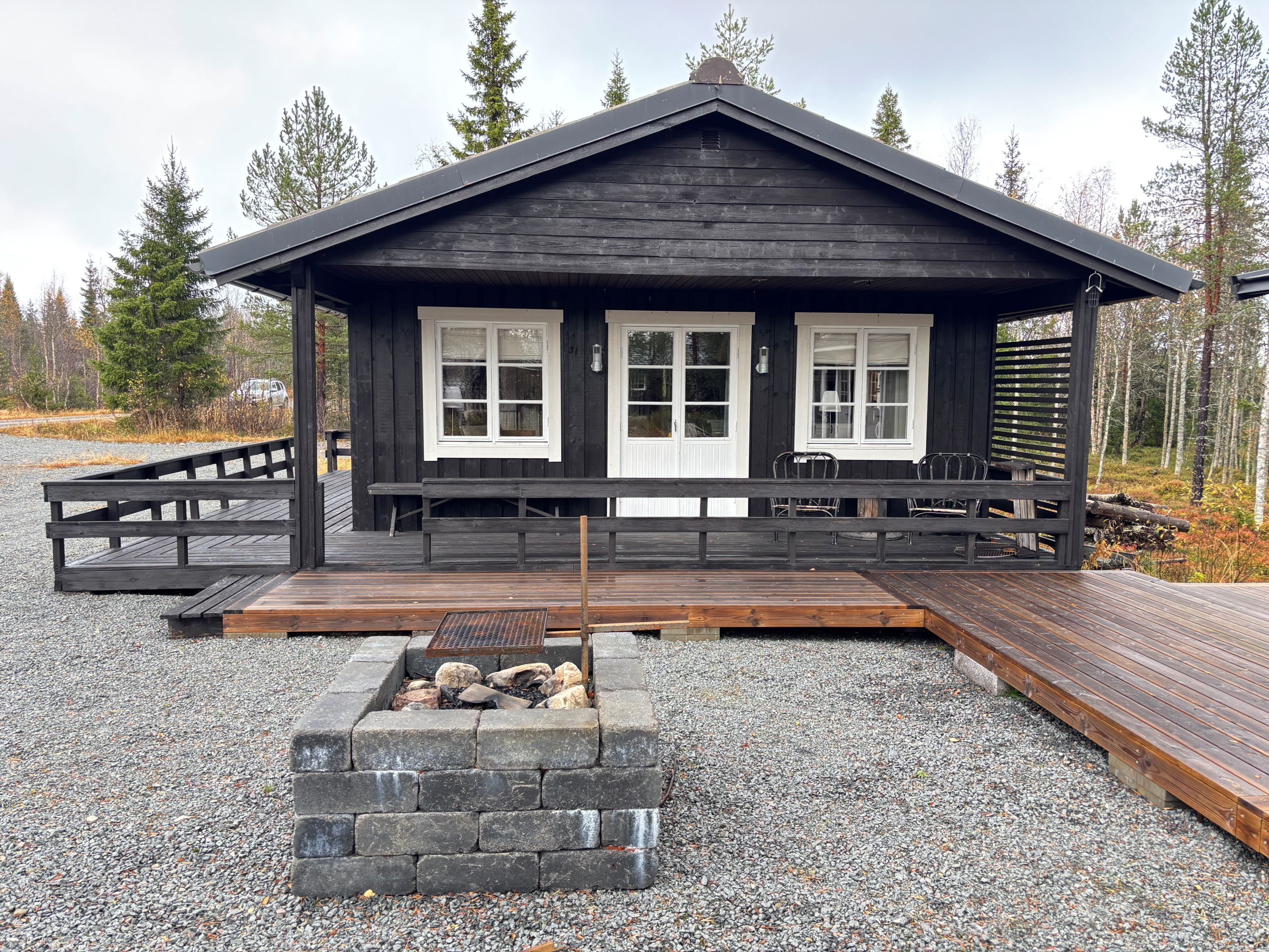 Huset med ute eldstad och altangolv mellan byggnaderna
