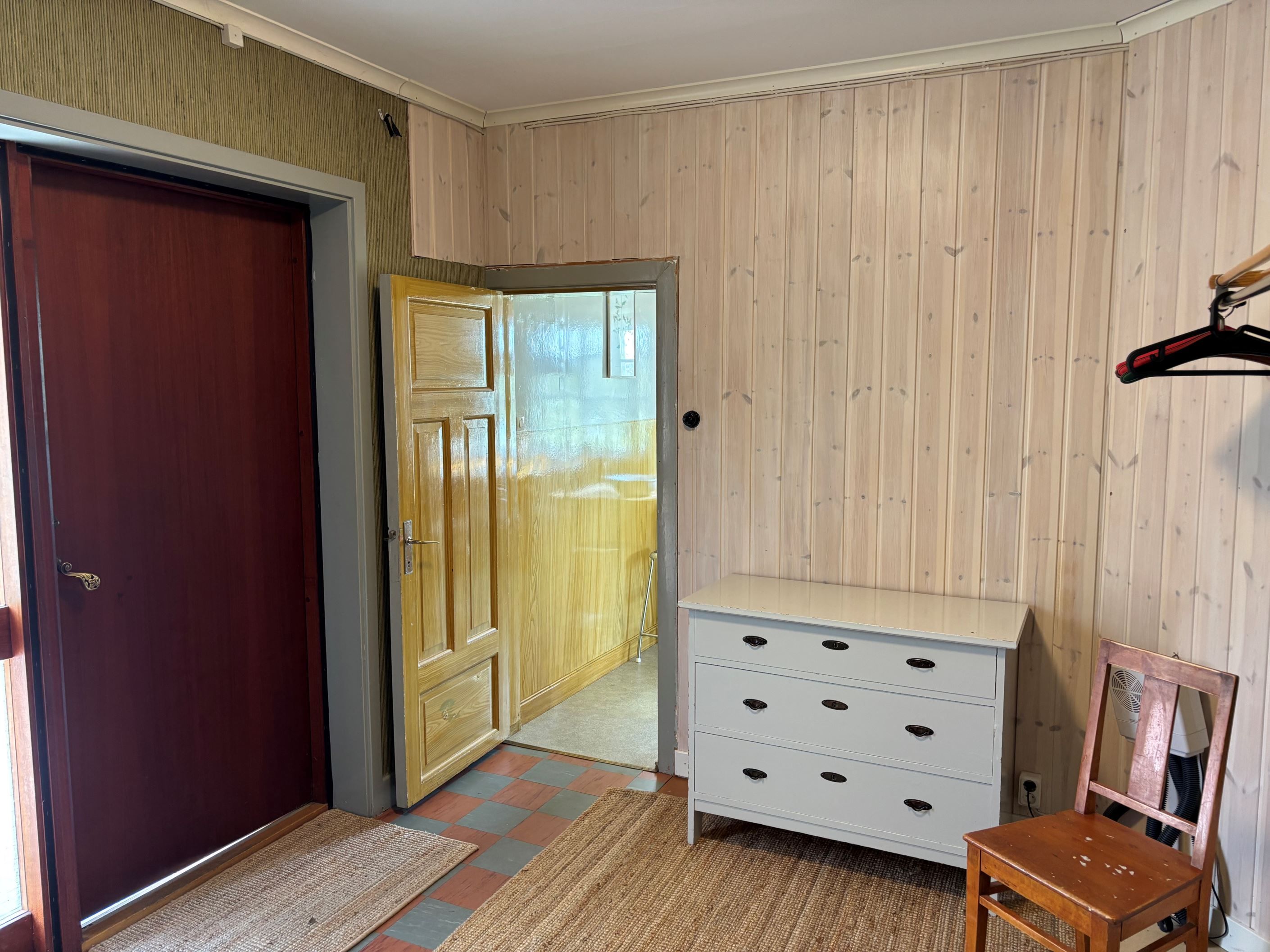 Hall med dörr in till köket i bild