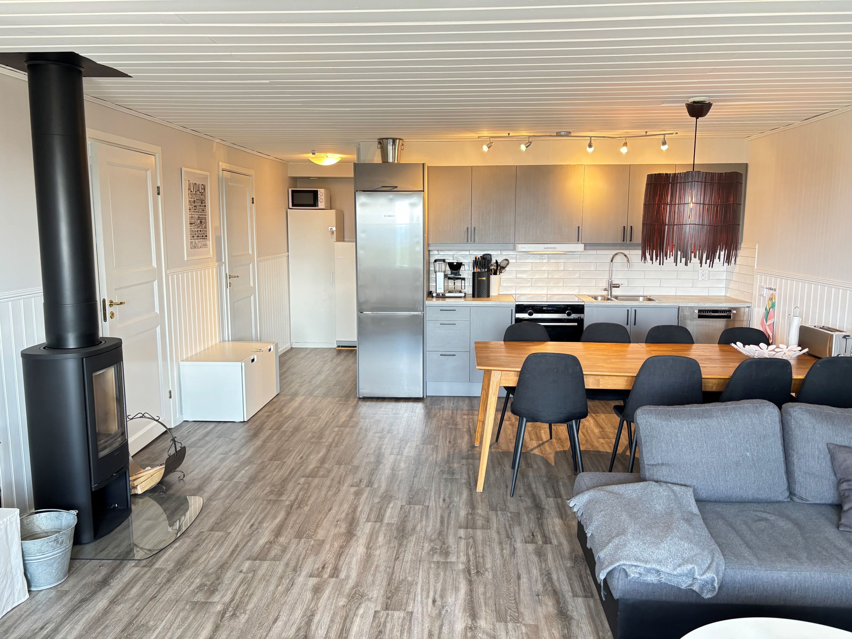 Allrum/kök med kamin och sovrum 1 och 3 t.v i bild