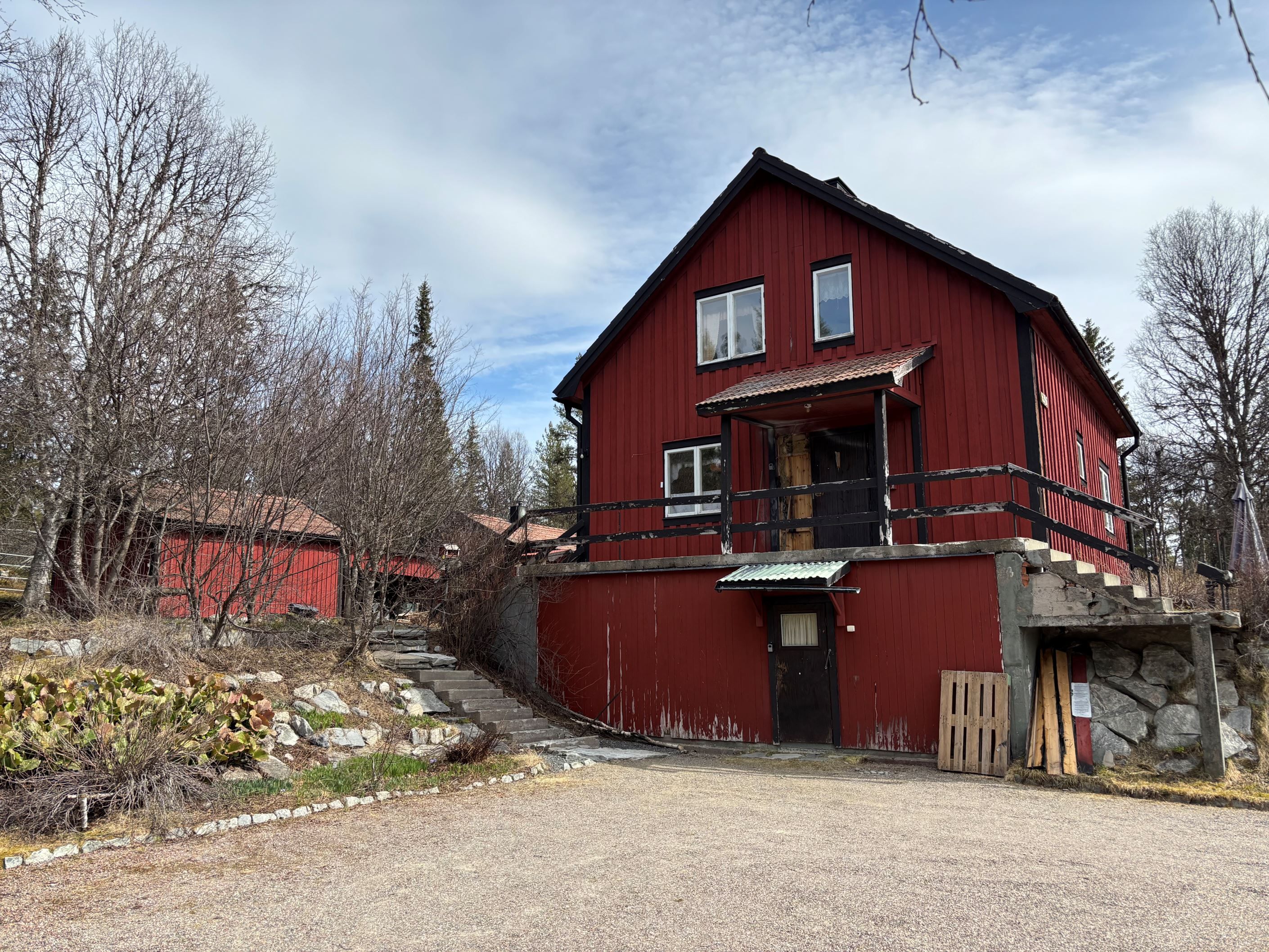Huset sett från infarten och parkeringen
