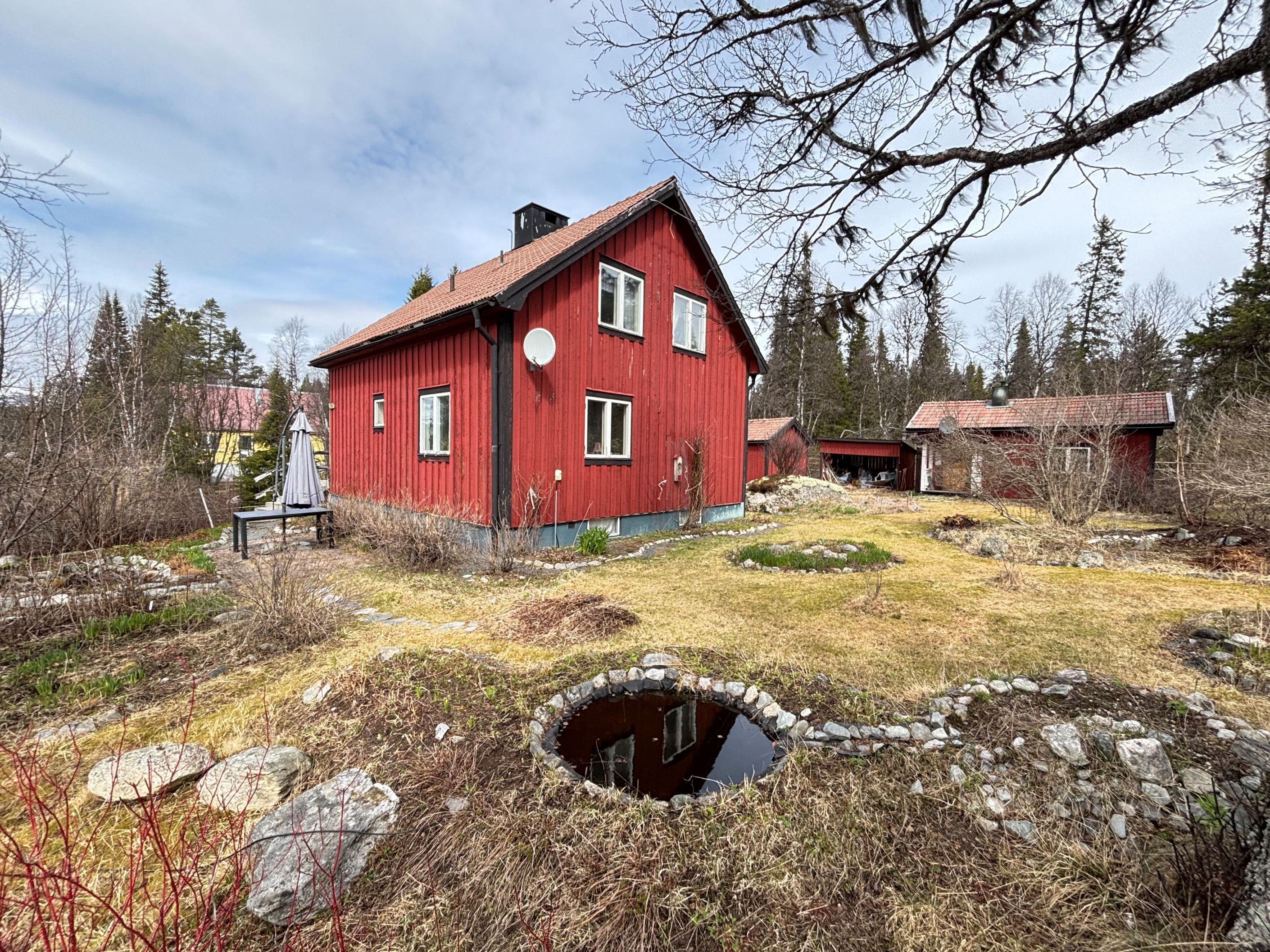 Huset sett från söder med trädgård och gäststugan
