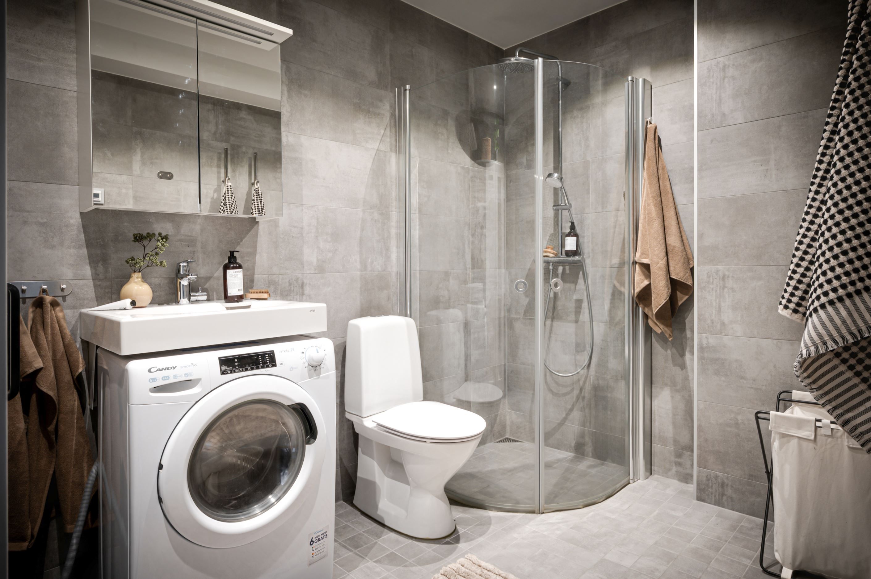 Modernt badrum med golvvärme samt kombinerad tvätt och torkmaskin