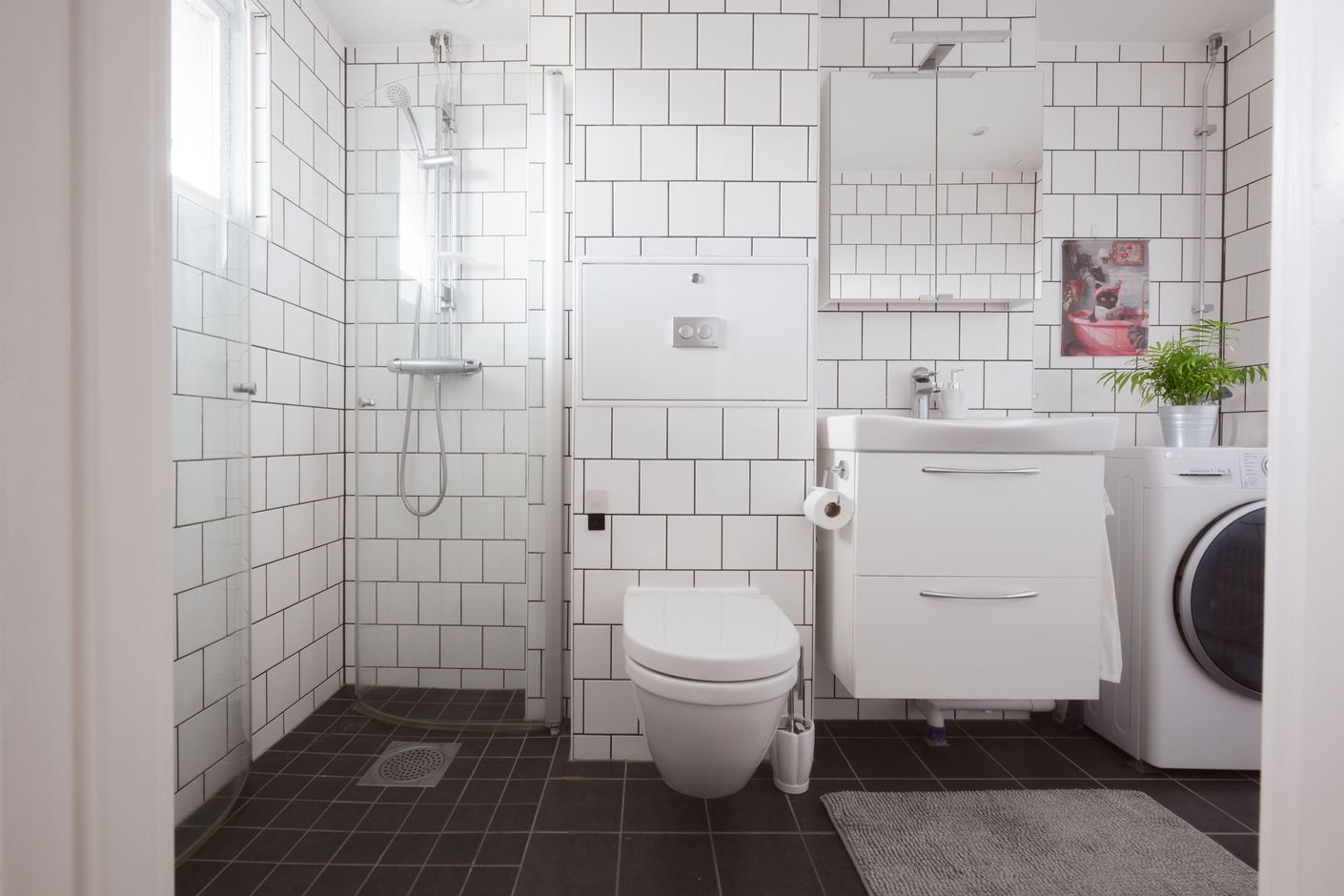Modernt badrum med kombinerad tvätt och torkmaskin