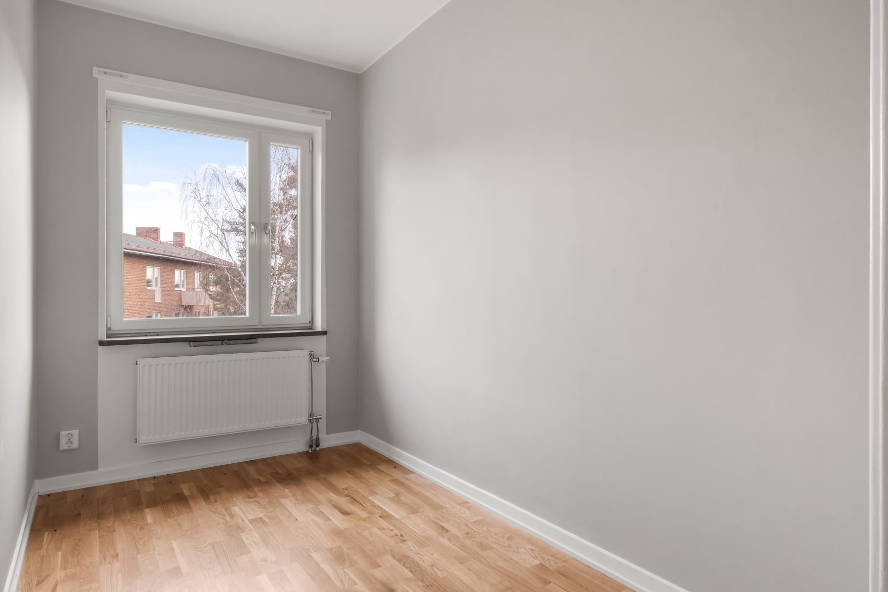 Ljust och trivsamt sovrum med plats för säng och förvaring