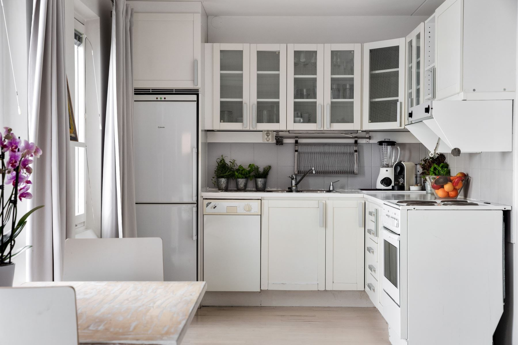 Kök med vita snickerier och diskmaskin