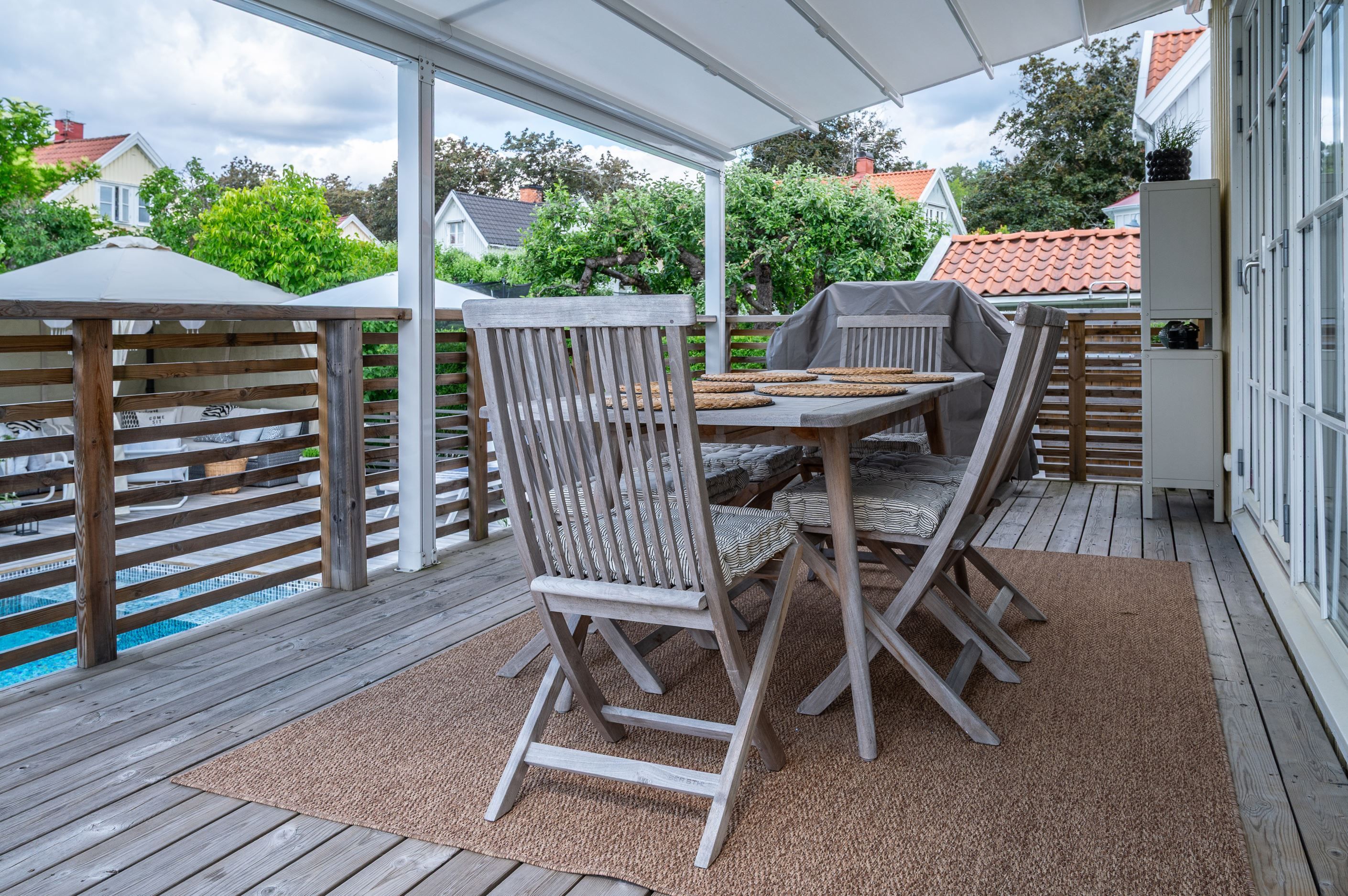 Altanen under tak binder trivsamt samman hus med trädgård