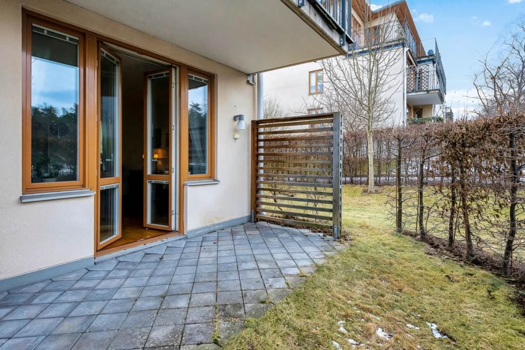 Stensatt uteplats med plats för utemöbel och grill