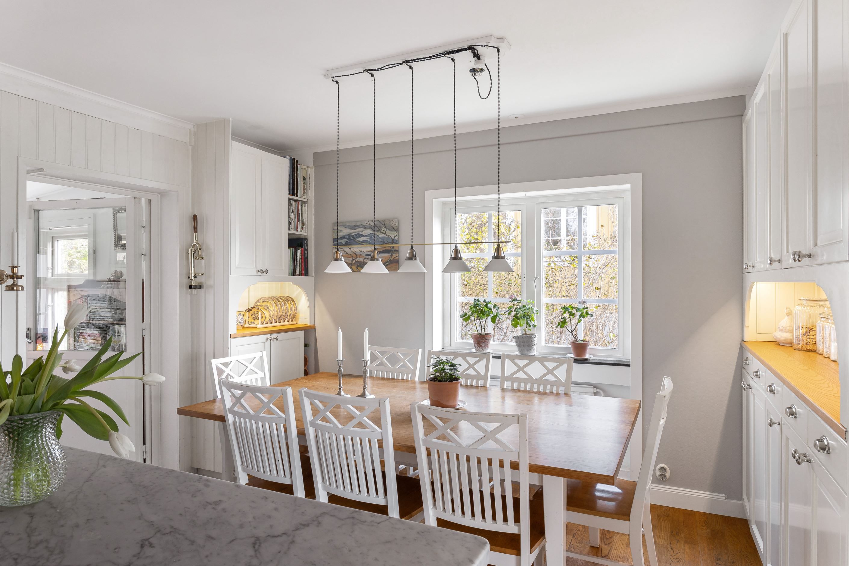 Kök med glasat uterum i fil ger härlig kontakt med trädgården