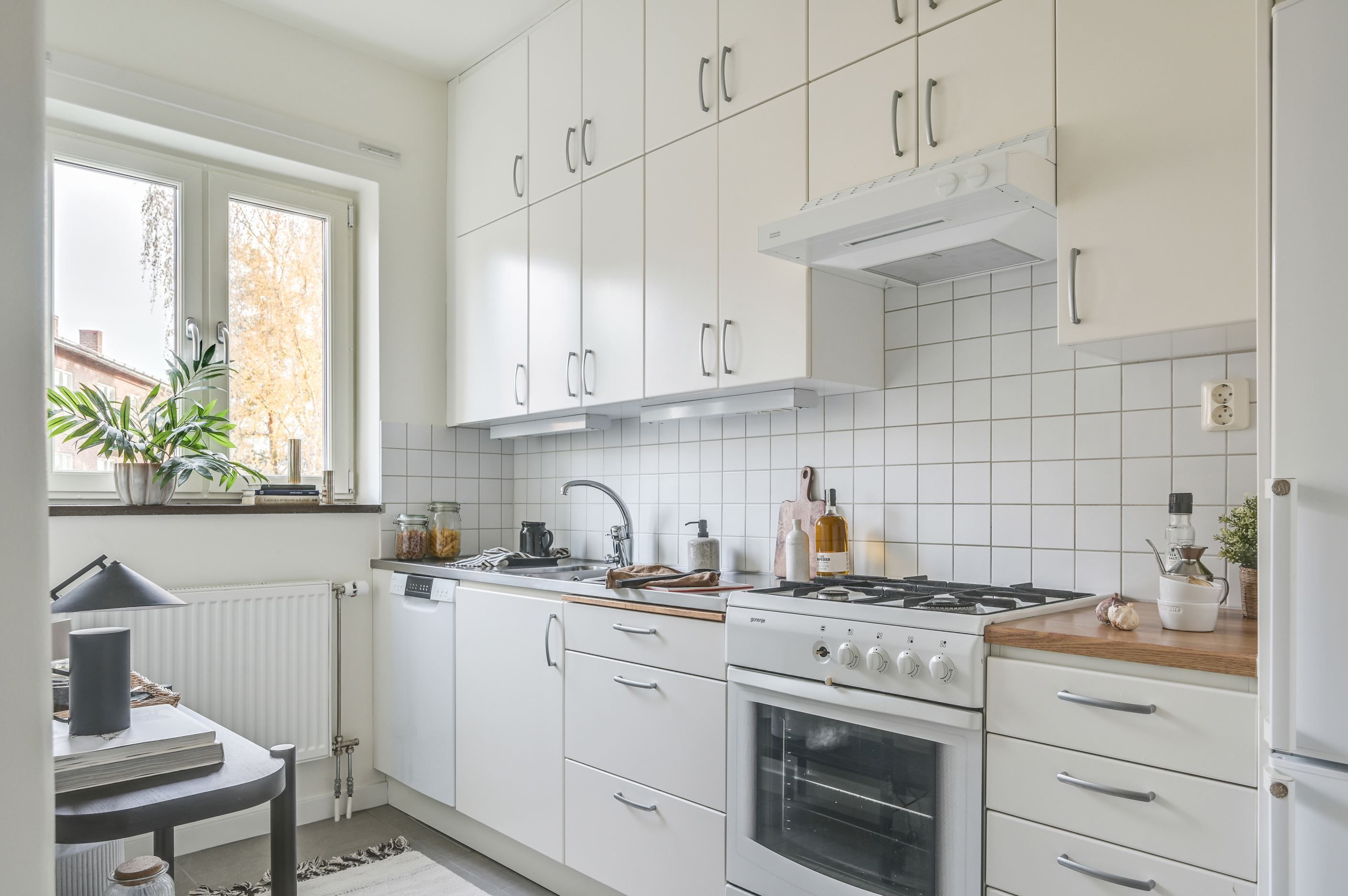 Vitt och funktionellt kök med gott om förvaring enda upp till taket