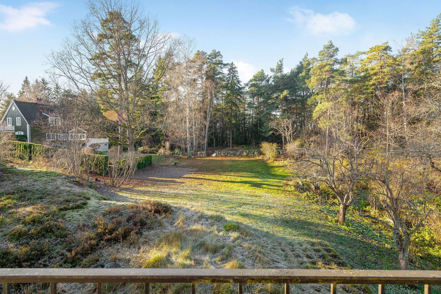 Storslagen vy från huset mot den soldränkta tomten i efterfrågat läge nära Ålstens Torg