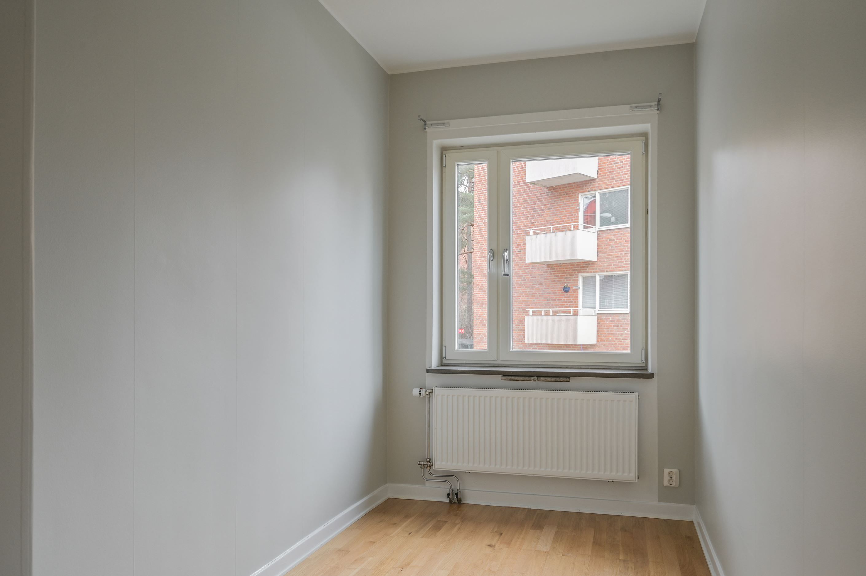 Trivsamt sovrum med plats för dubbelsäng och förvaringsmöbel