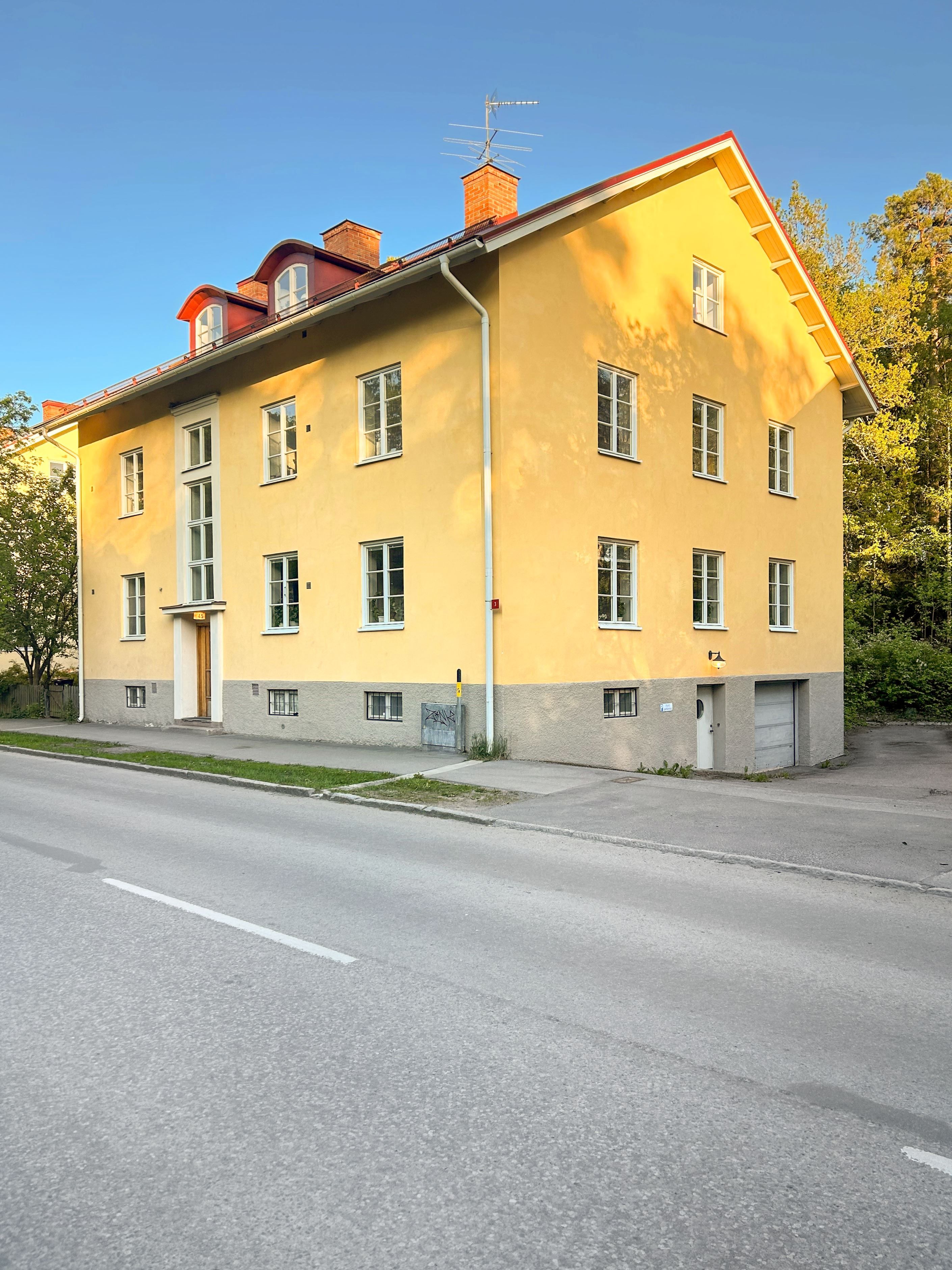 Ingång till källarplanet från kortsidan samt garageport till garaget