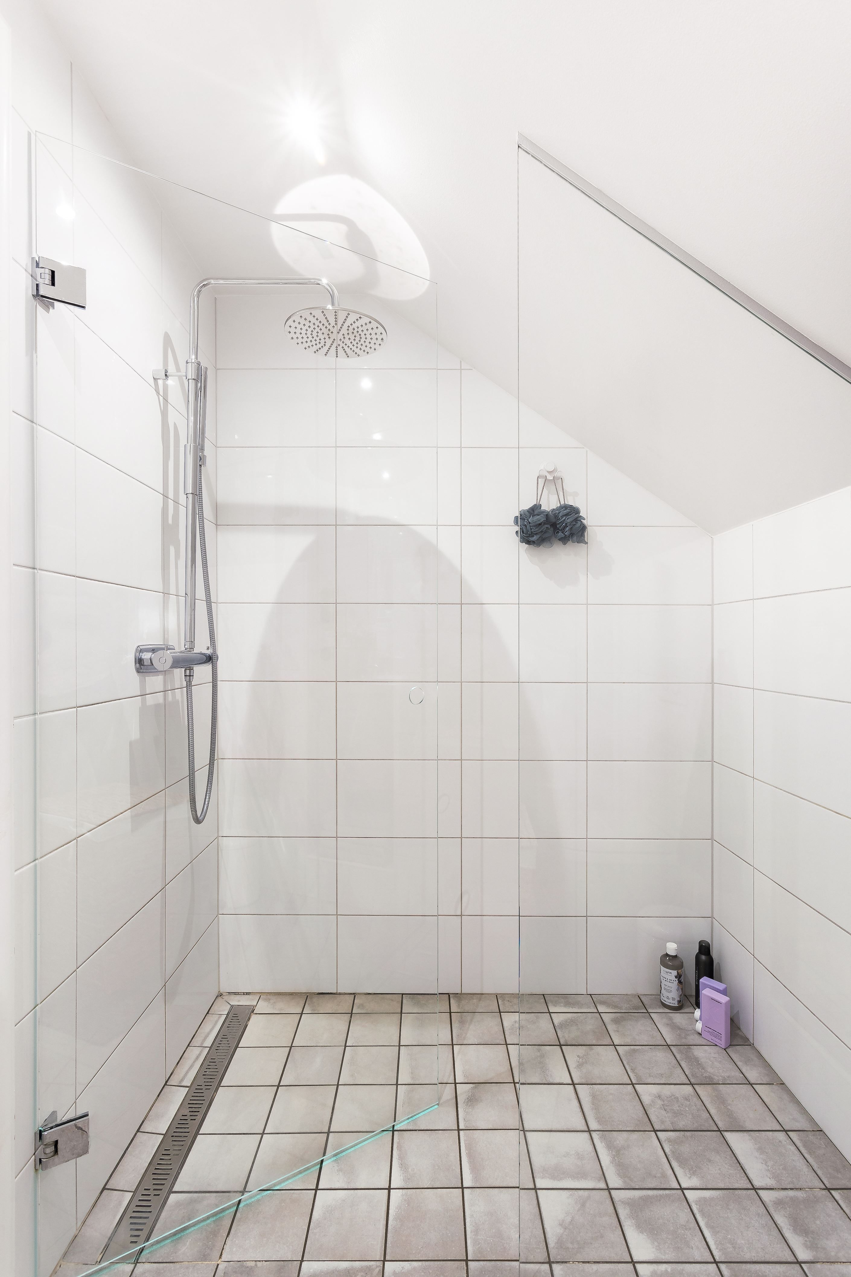 Badrum övre plan med dusch bakom glasad vikvägg