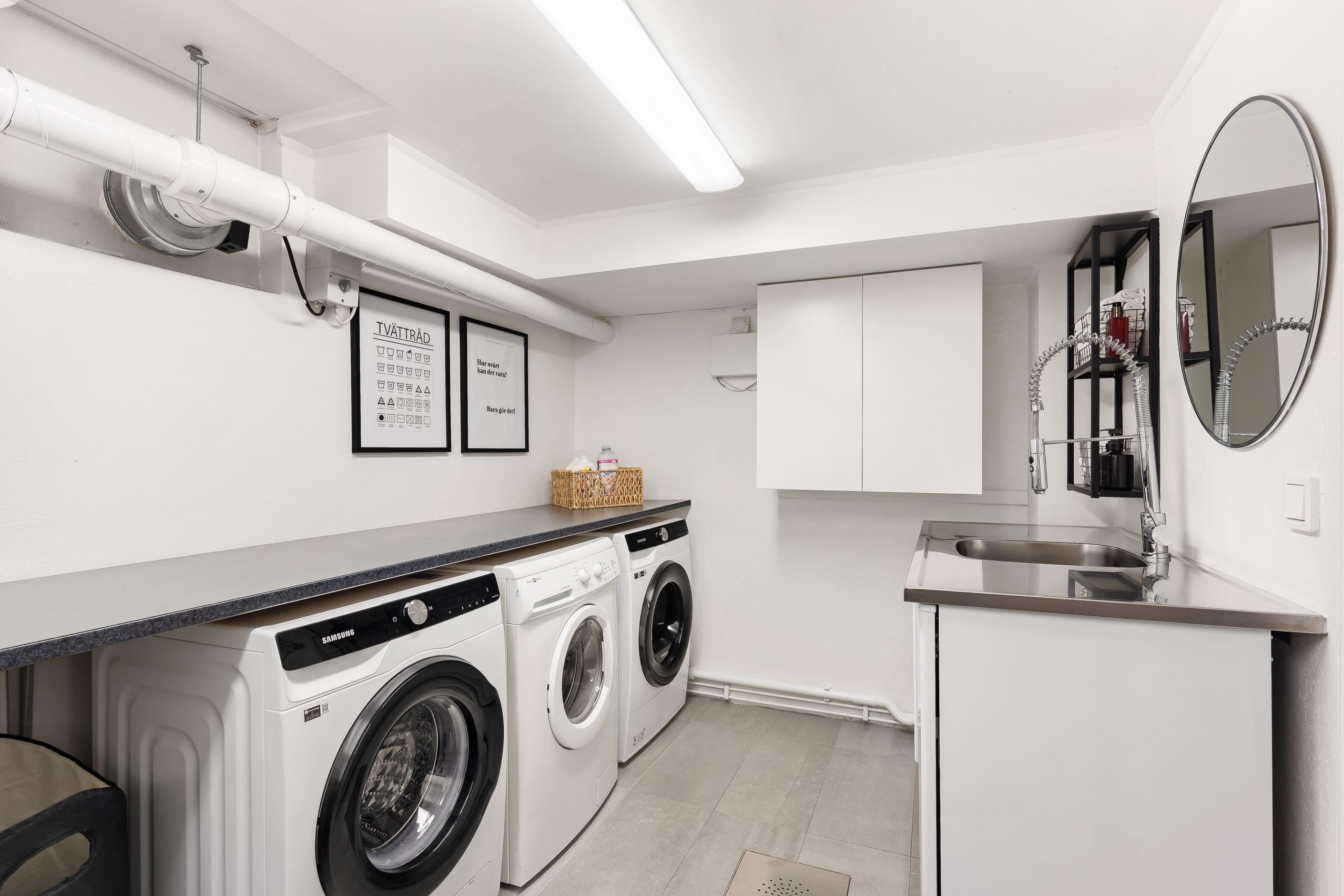 Tvättstuga på nedre plan med dubbla maskiner och bra arbetsyta