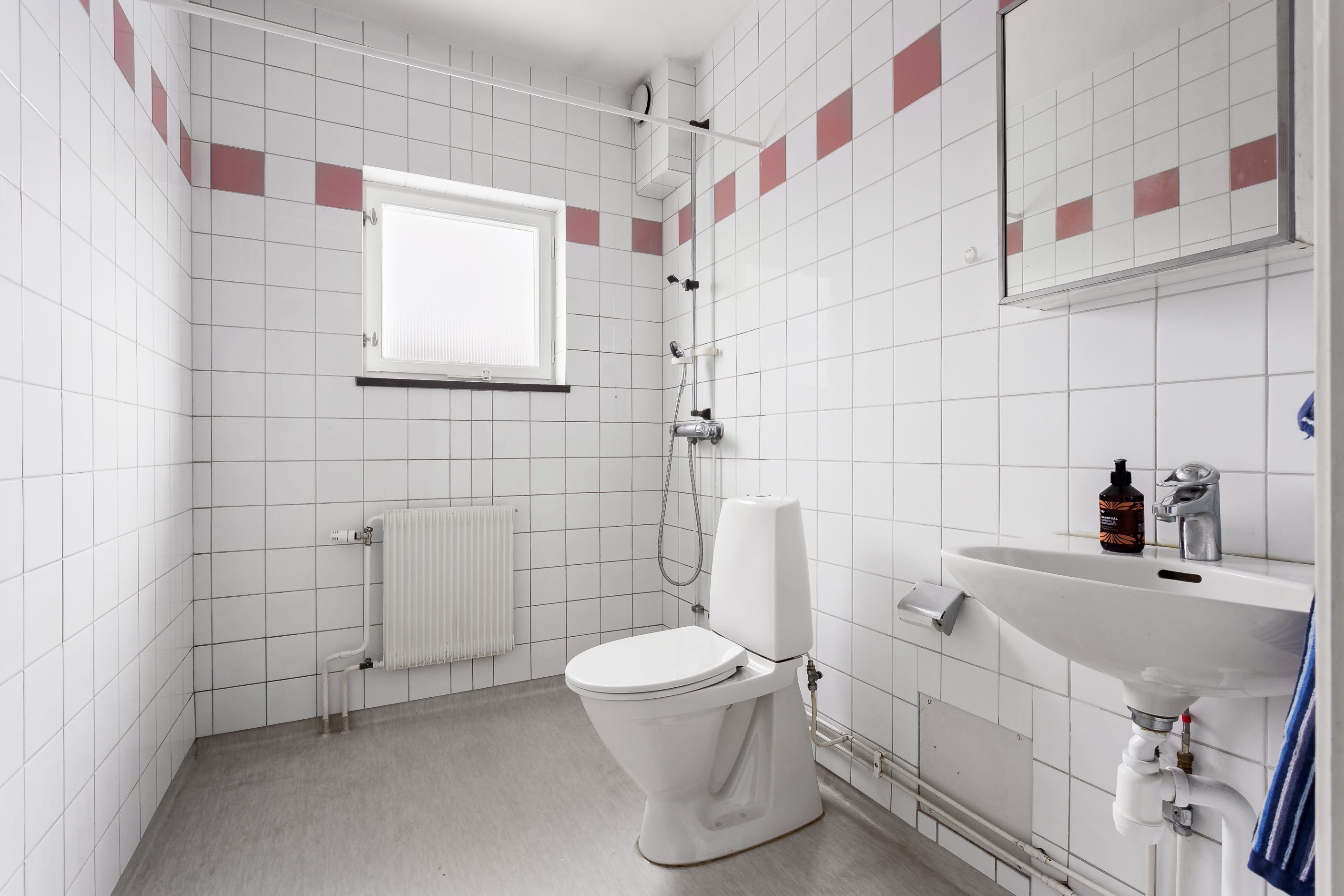 Rymligt badrum med dusch och fönster för ljusinsläpp