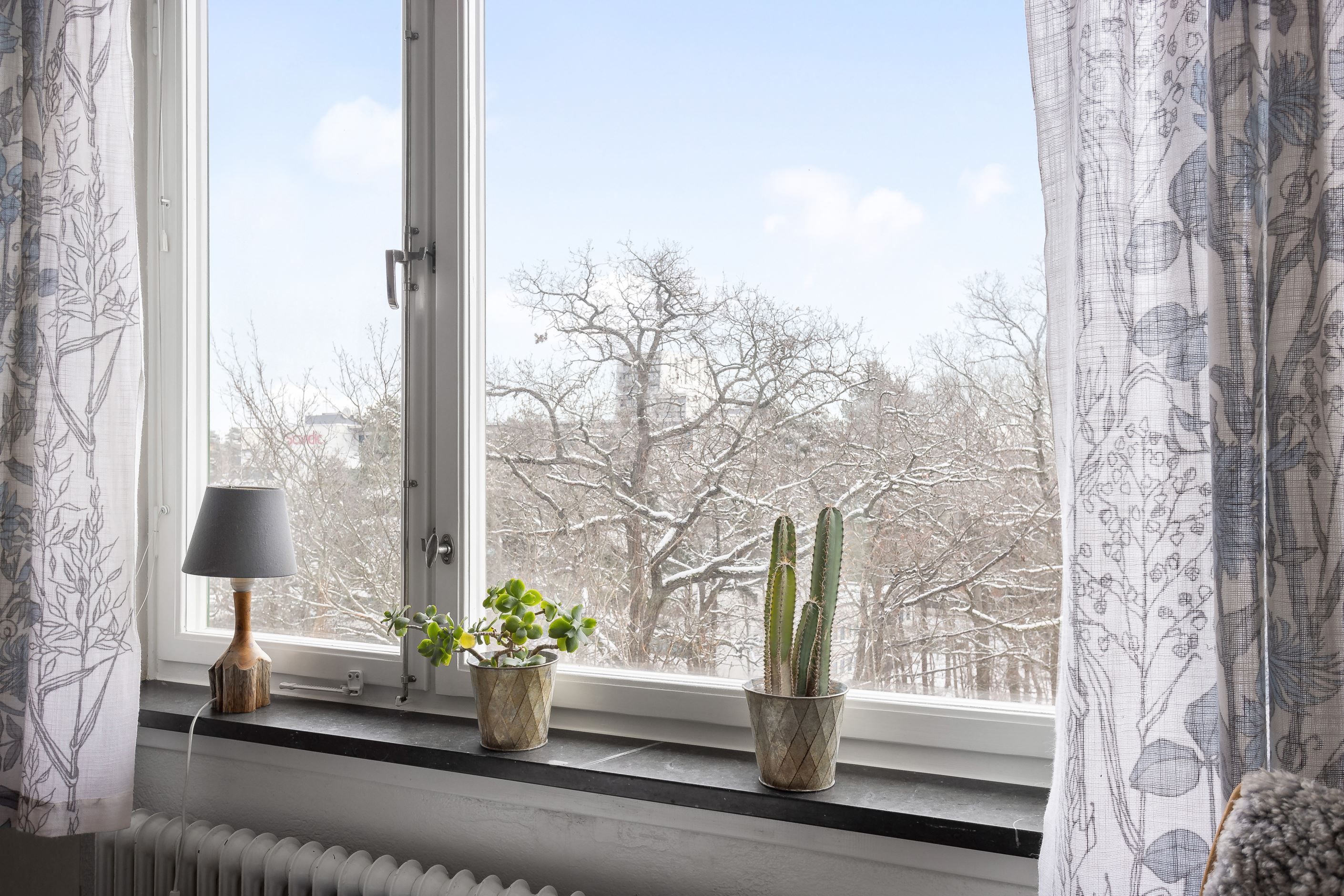 Hela lägenheten omges av grönskande skogsparti som bäddar in hemmet i ett lugn