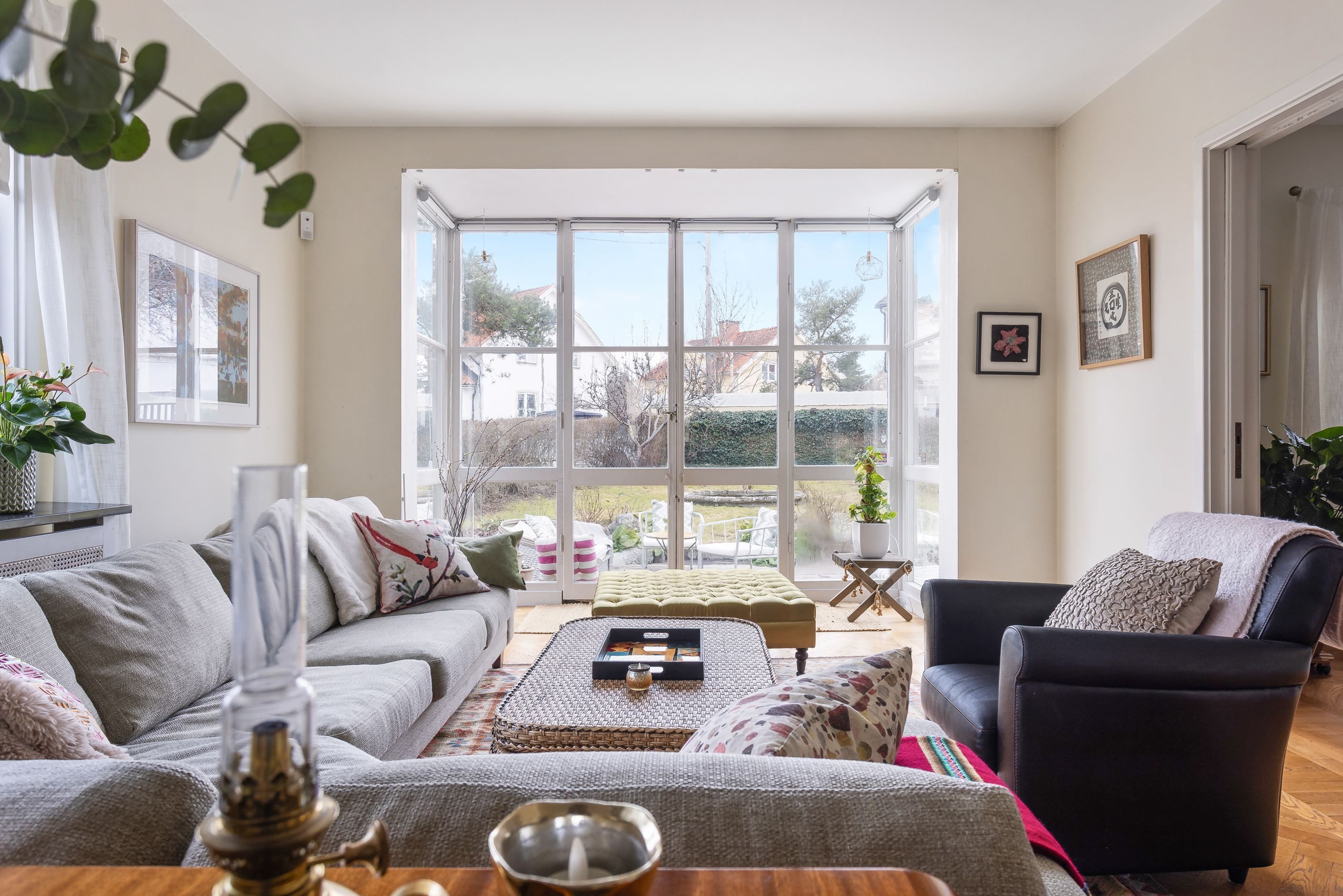 Generös sällskapsyta där ljuset flödar in och glasad vägg utgör en "tavla" i rummet