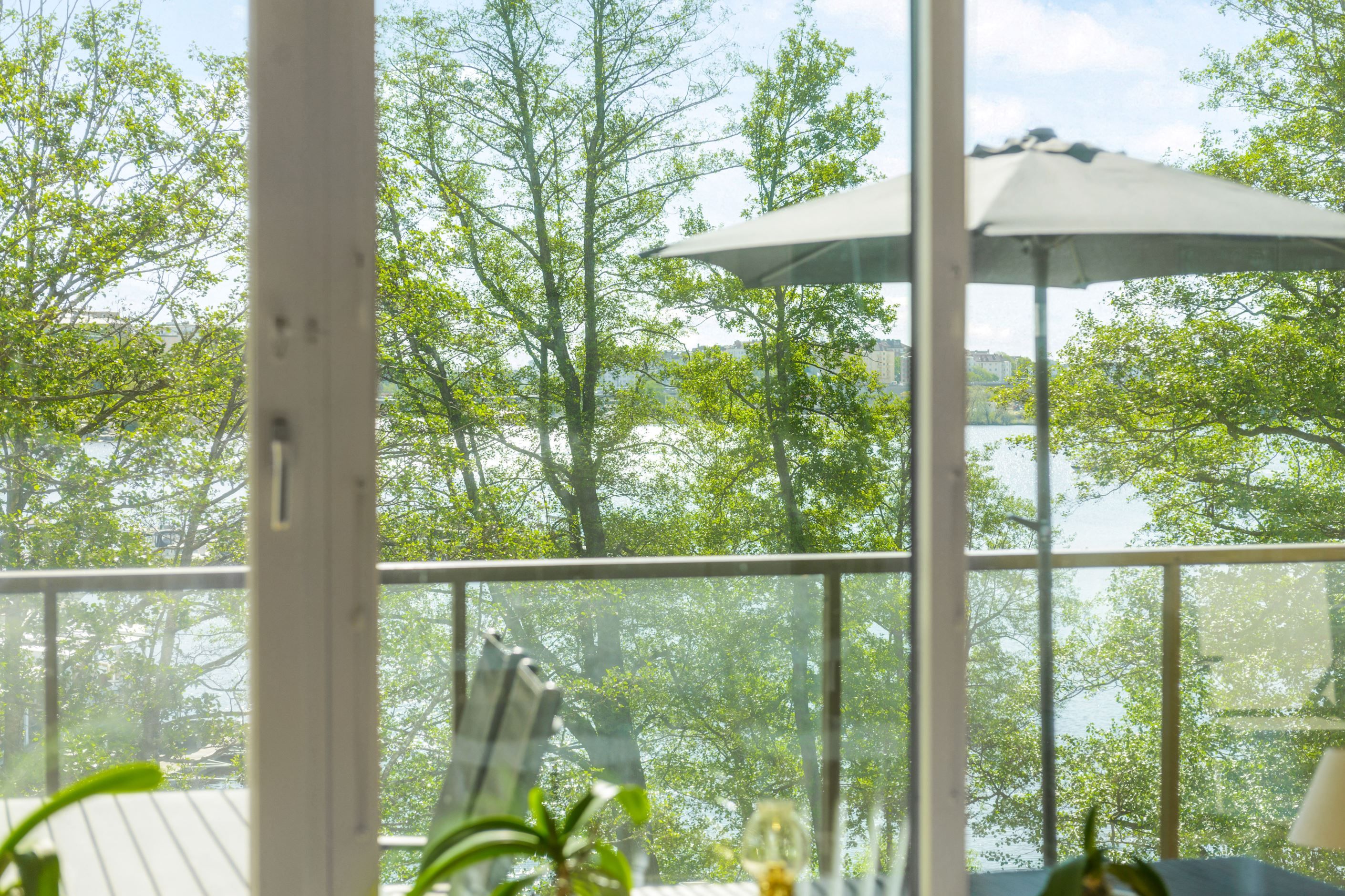 Trivsam inramning av grönska och Mälaren som glittrar i fonden