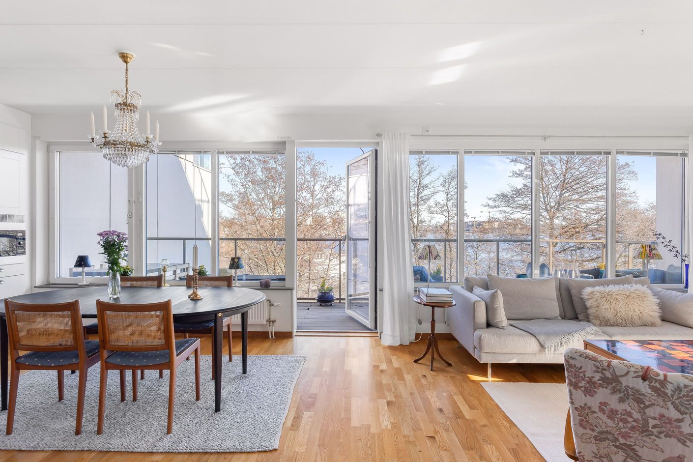 Glasad vägg ut mot altan om 26 kvm med fri vy mot Mälaren och frodig grönska