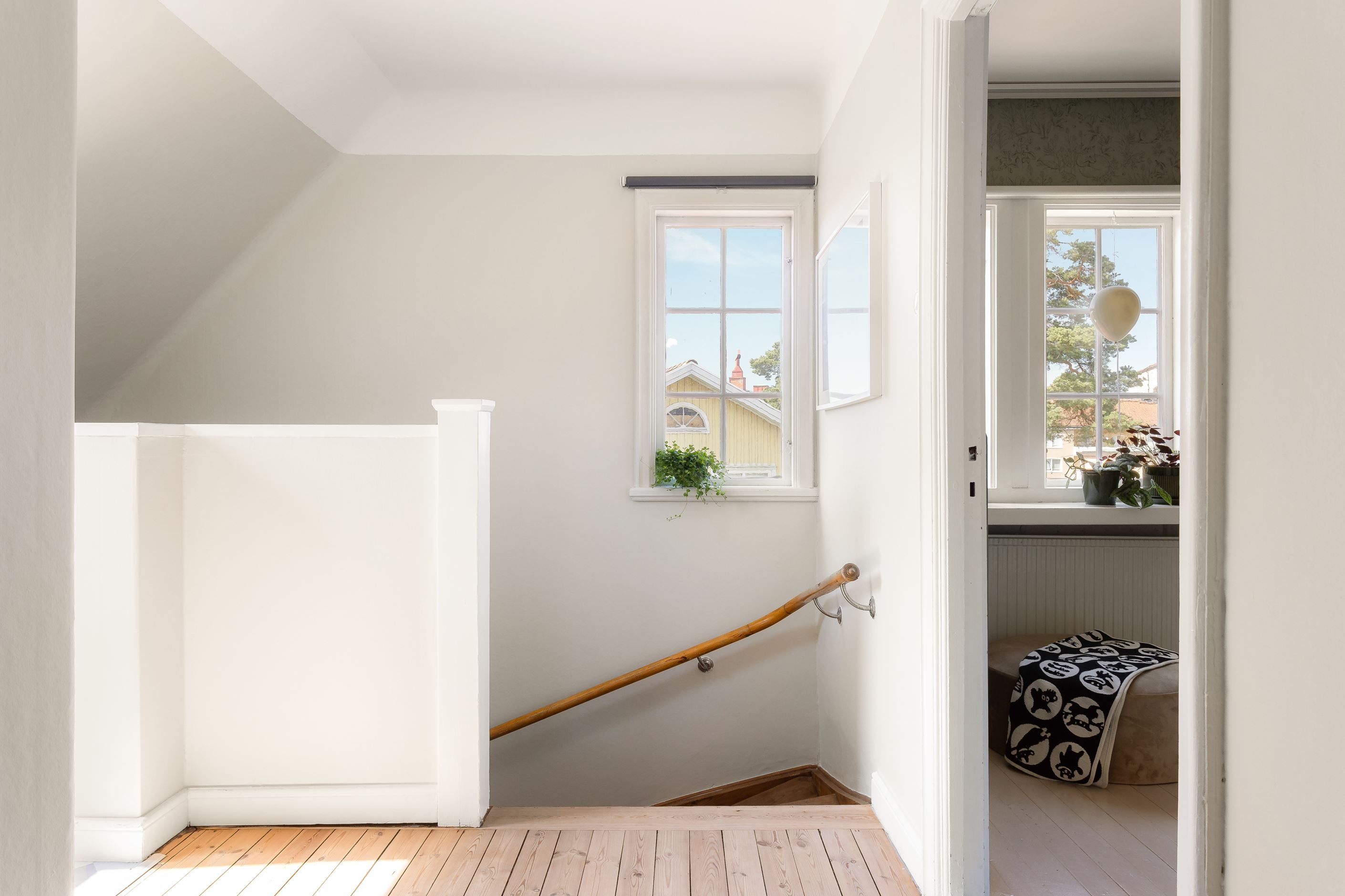 Övre hall med glasad dörr som leder ut till altan