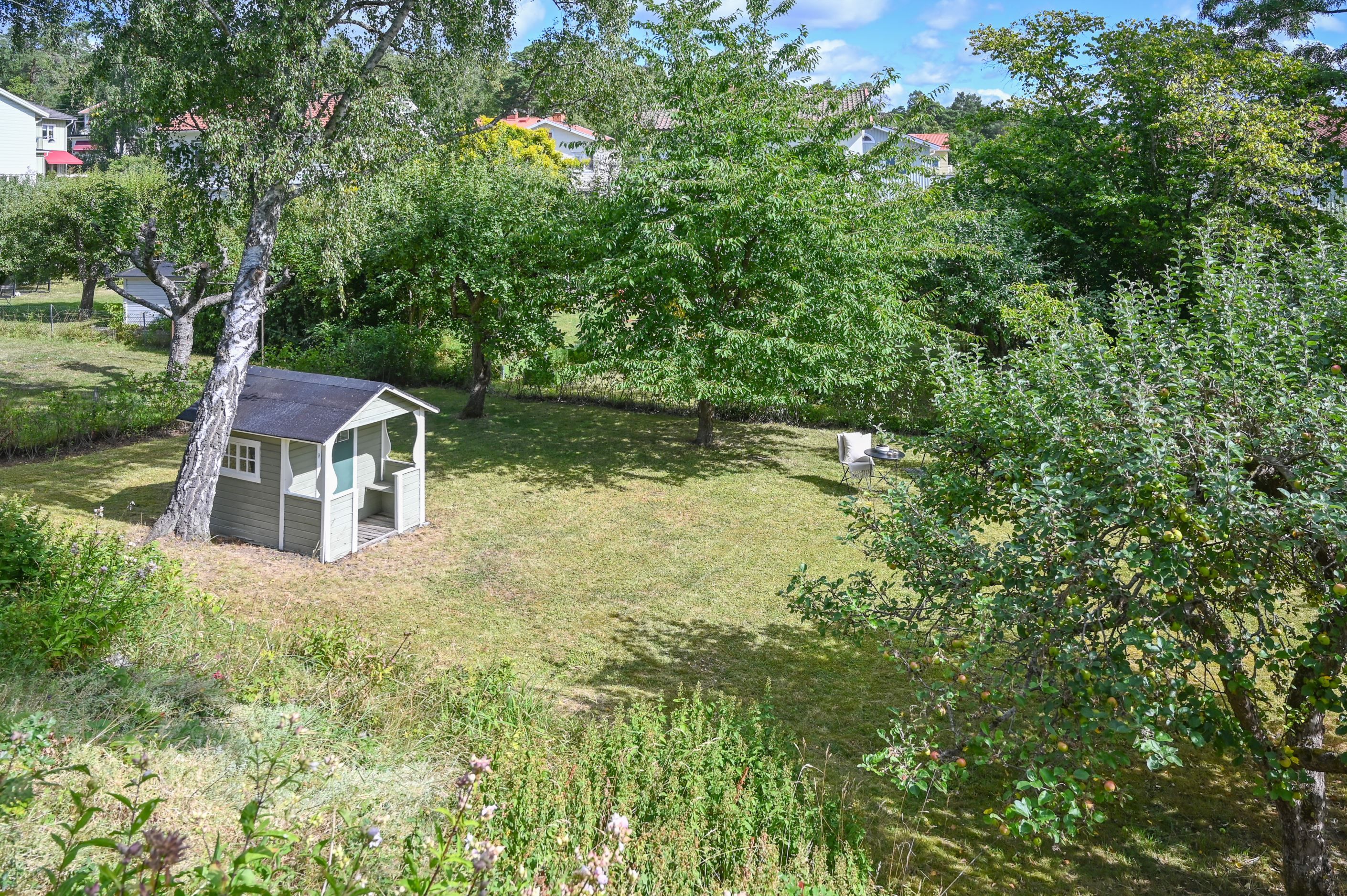 ...barnvänlig tomt med lekstuga och plana gräsytor