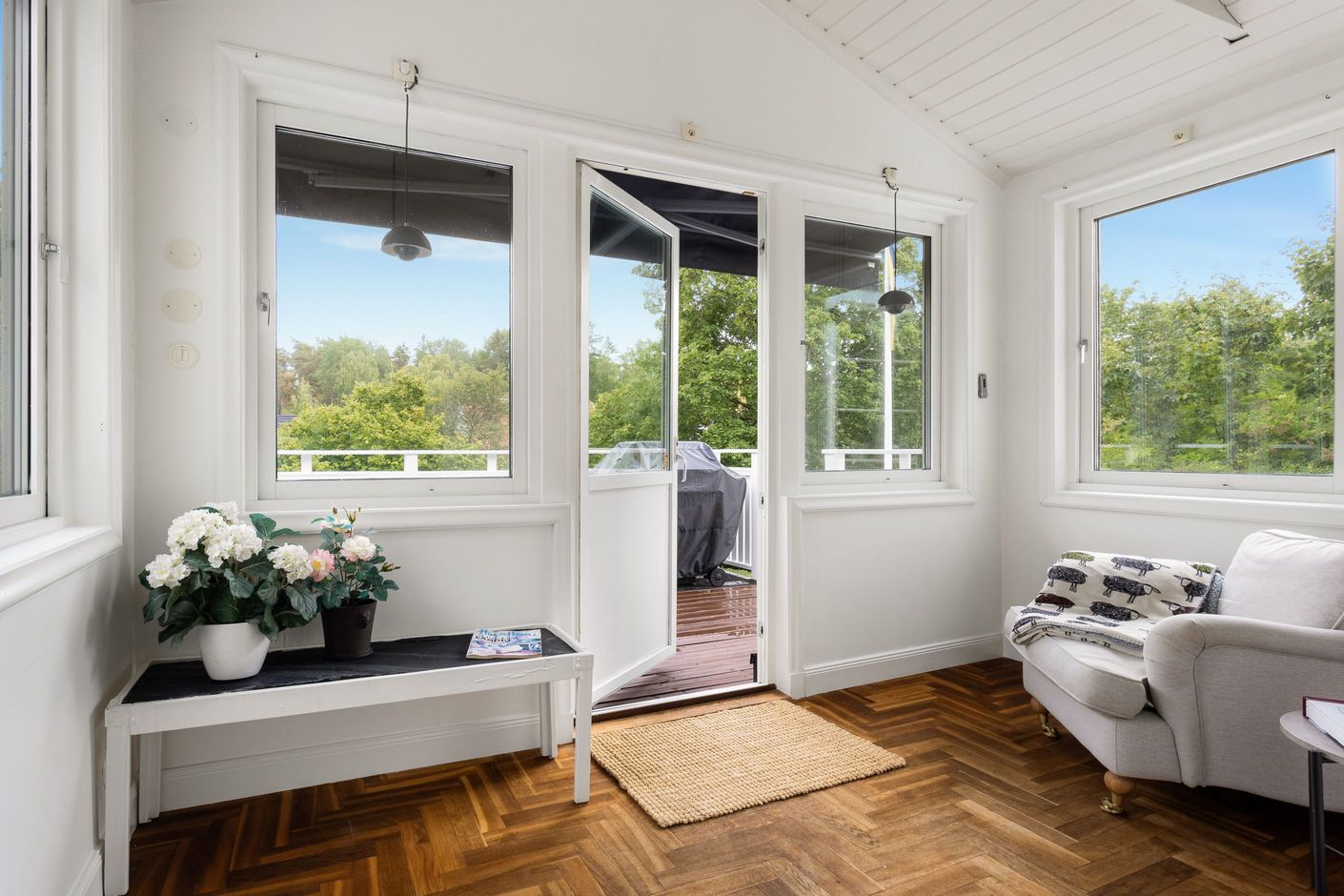 Via glasat blomsterrum nås den soliga altanen och trädgården