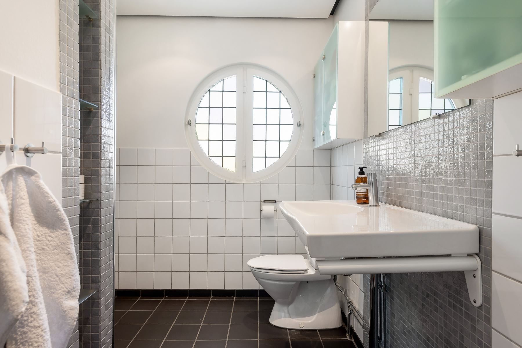 Gediget badrum på övre plan med charmigt fönster
