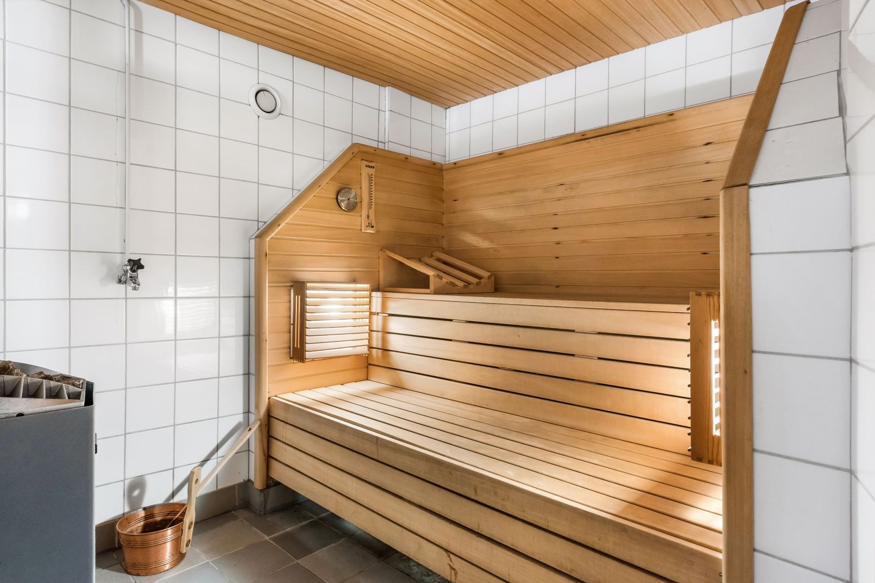 Gemensam bastu i källarplan med relaxyta