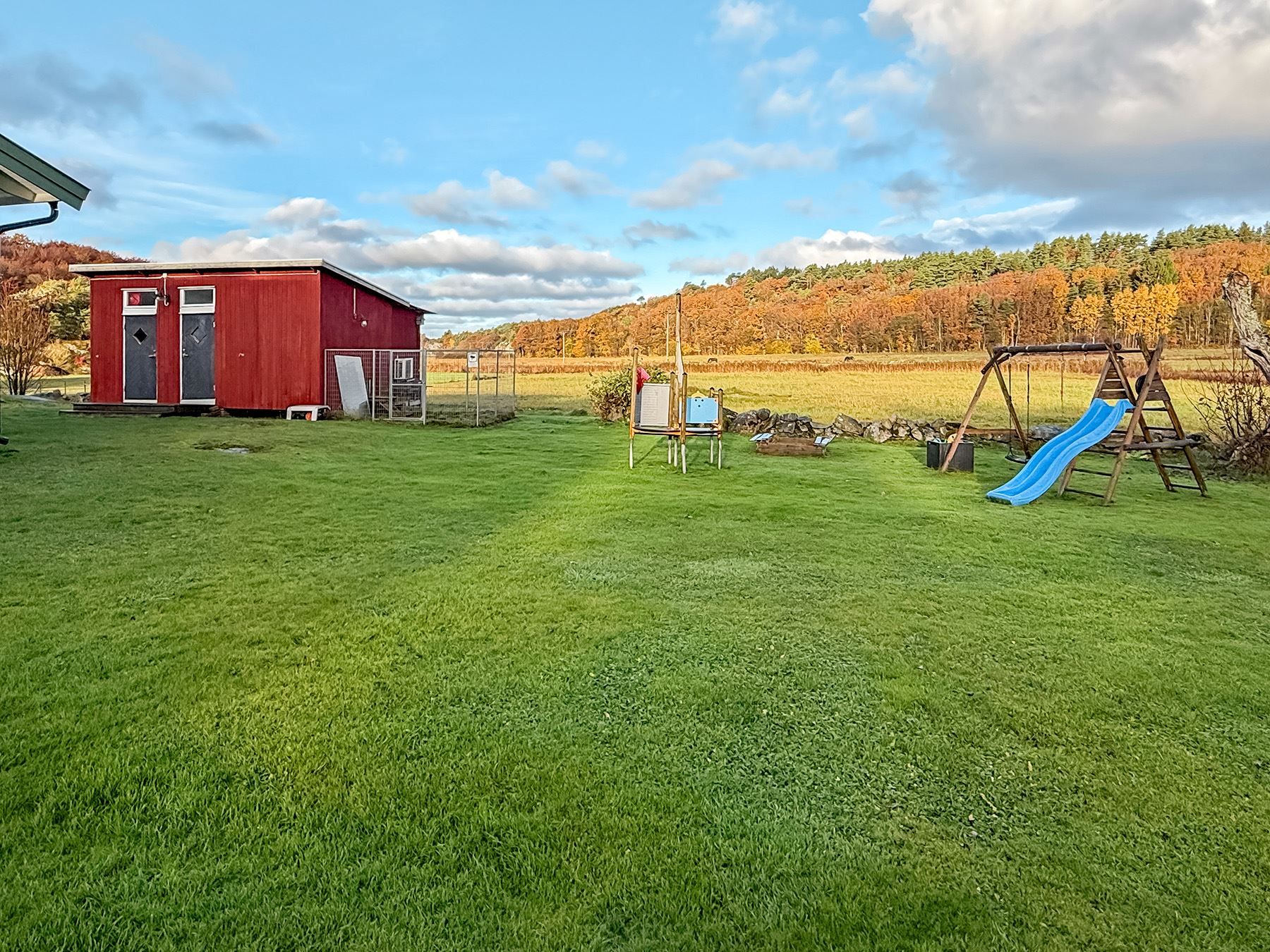 Njut av det öppna landskapet tillsammans med barnens skratt när de leker på den stora tomten.