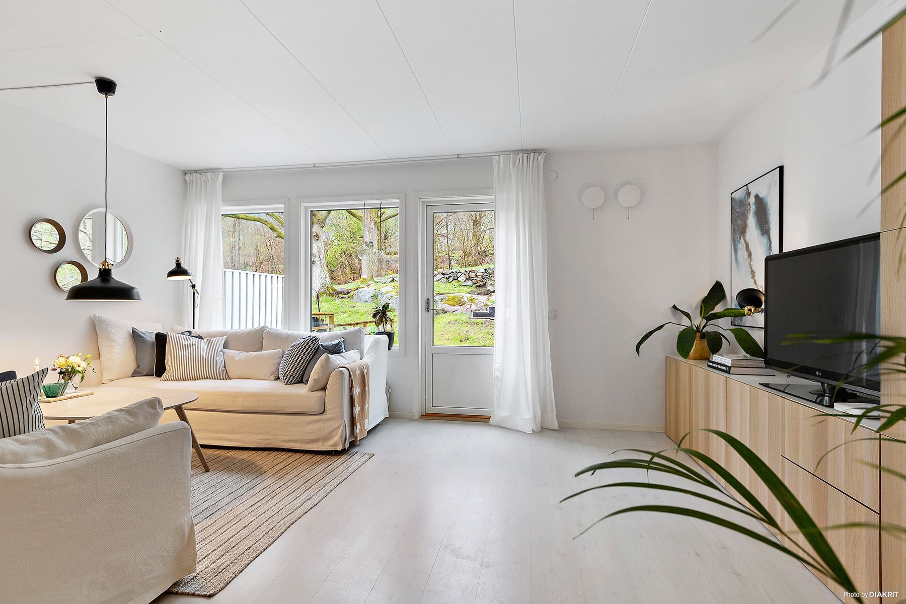 I vardagsrummet finns gott om plats för såväl soffgrupp som matgrupp. Naturen är alldeles utanför.