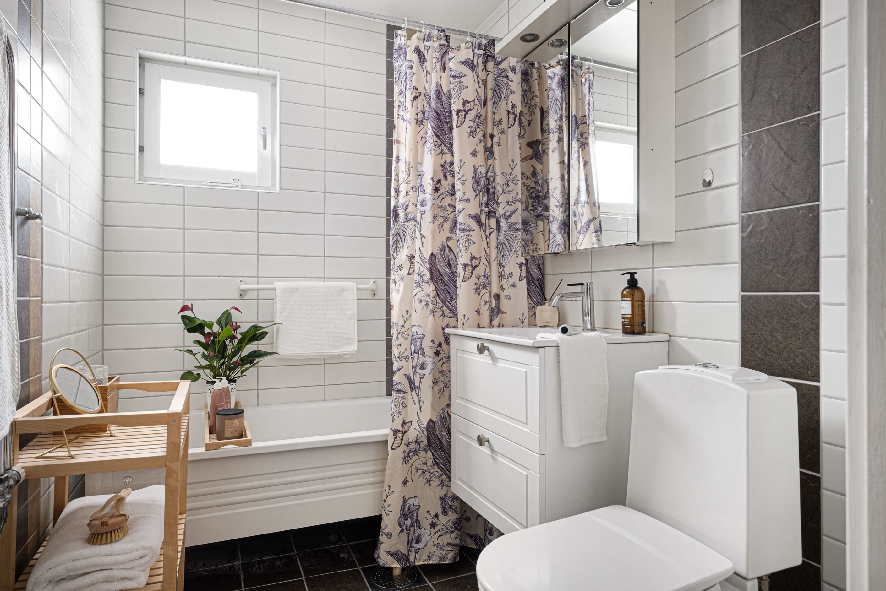 Det helkaklade badrummet har fönster för naturligt ljusinsläpp.