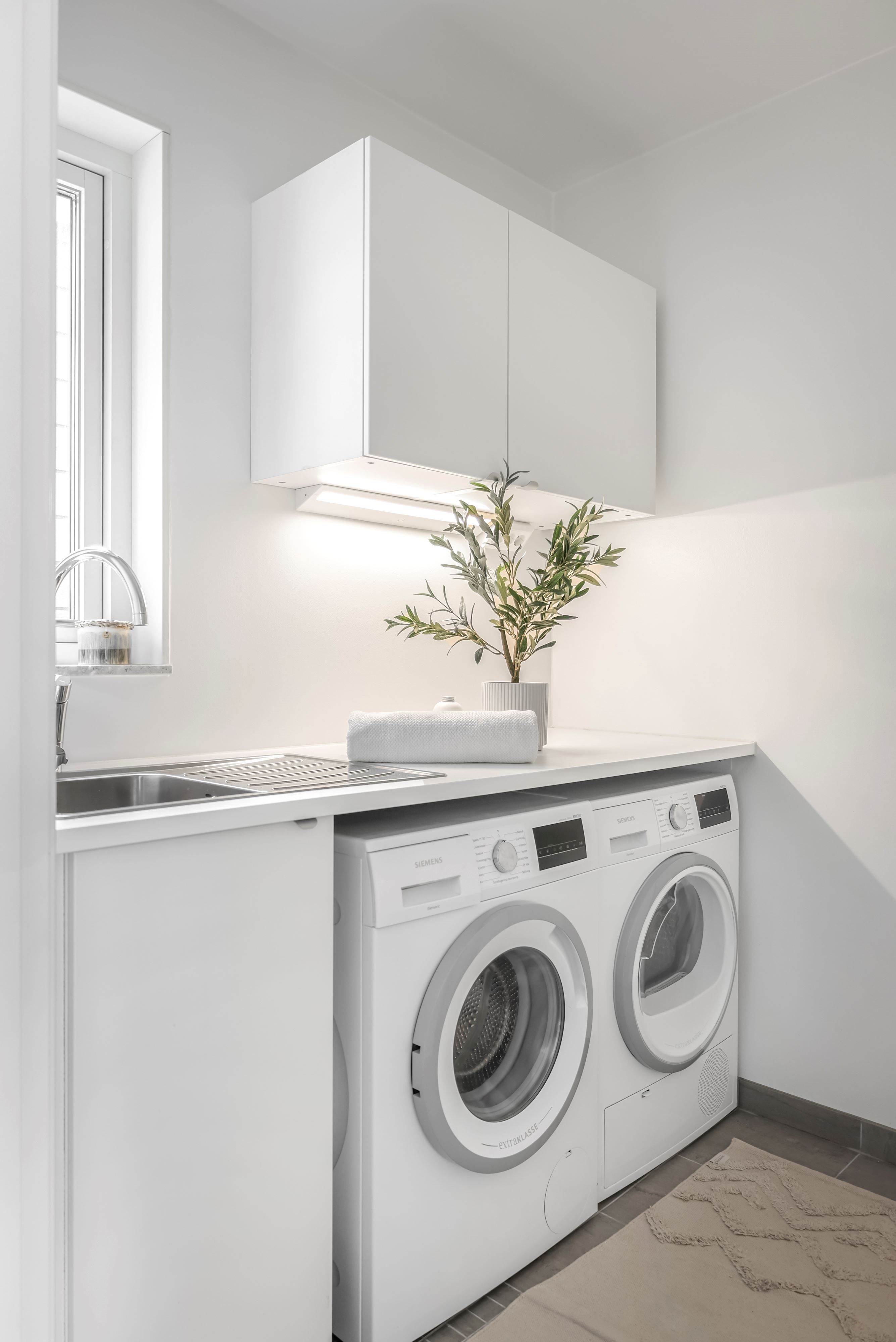 Den praktiska separata tvättstugan har fönster för naturligt ljusinsläpp.