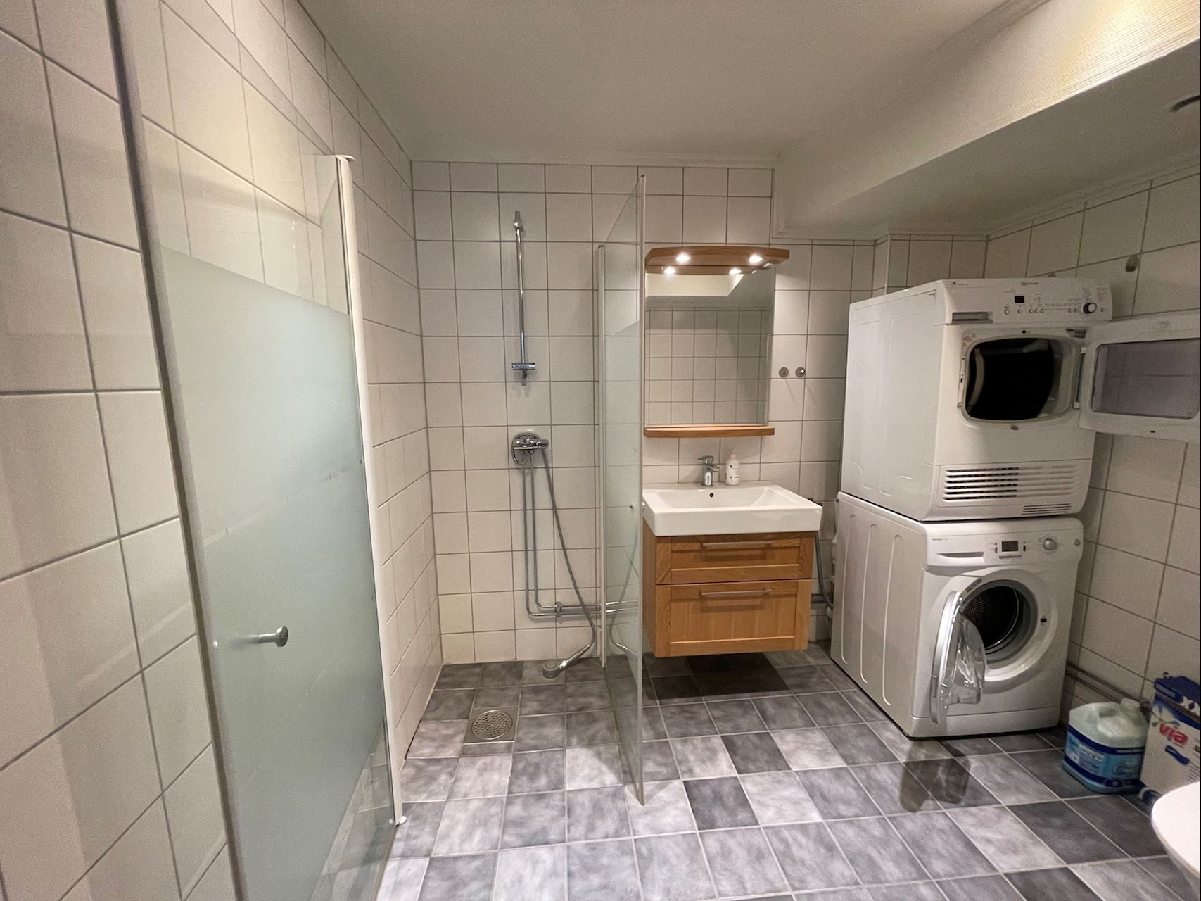 Helkaklat badrum i en av lägenheterna på nedre plan, säljarens bild.