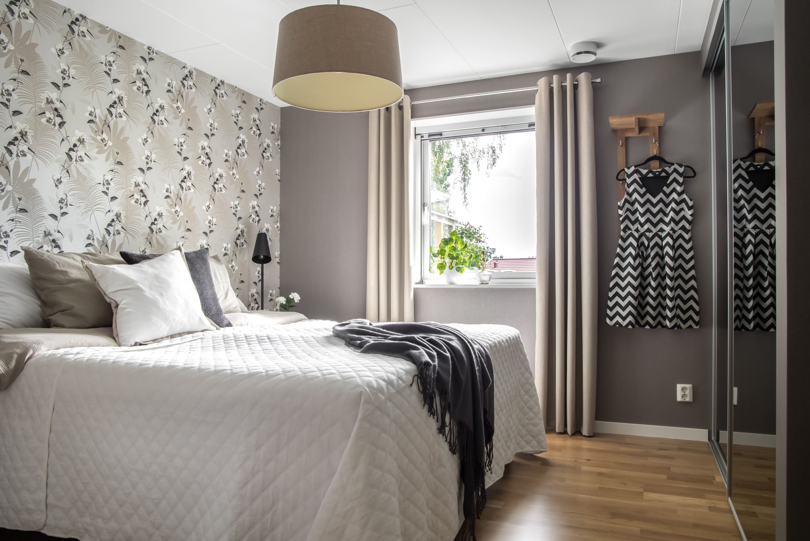 Det första ni möts av är ett stort sovrum med skjutdörrsgarderober.