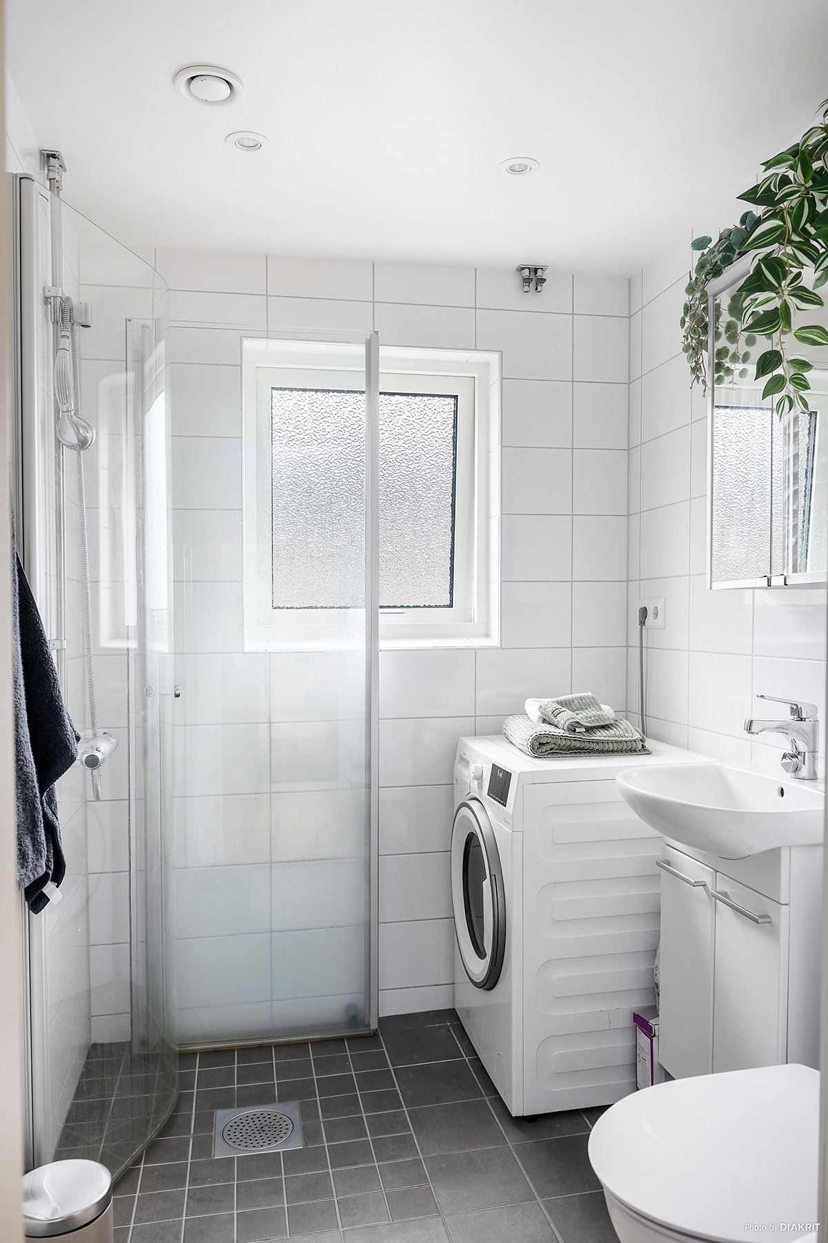 Det kanonfina helkaklade badrummet med fönster och tvättmöjligheter.