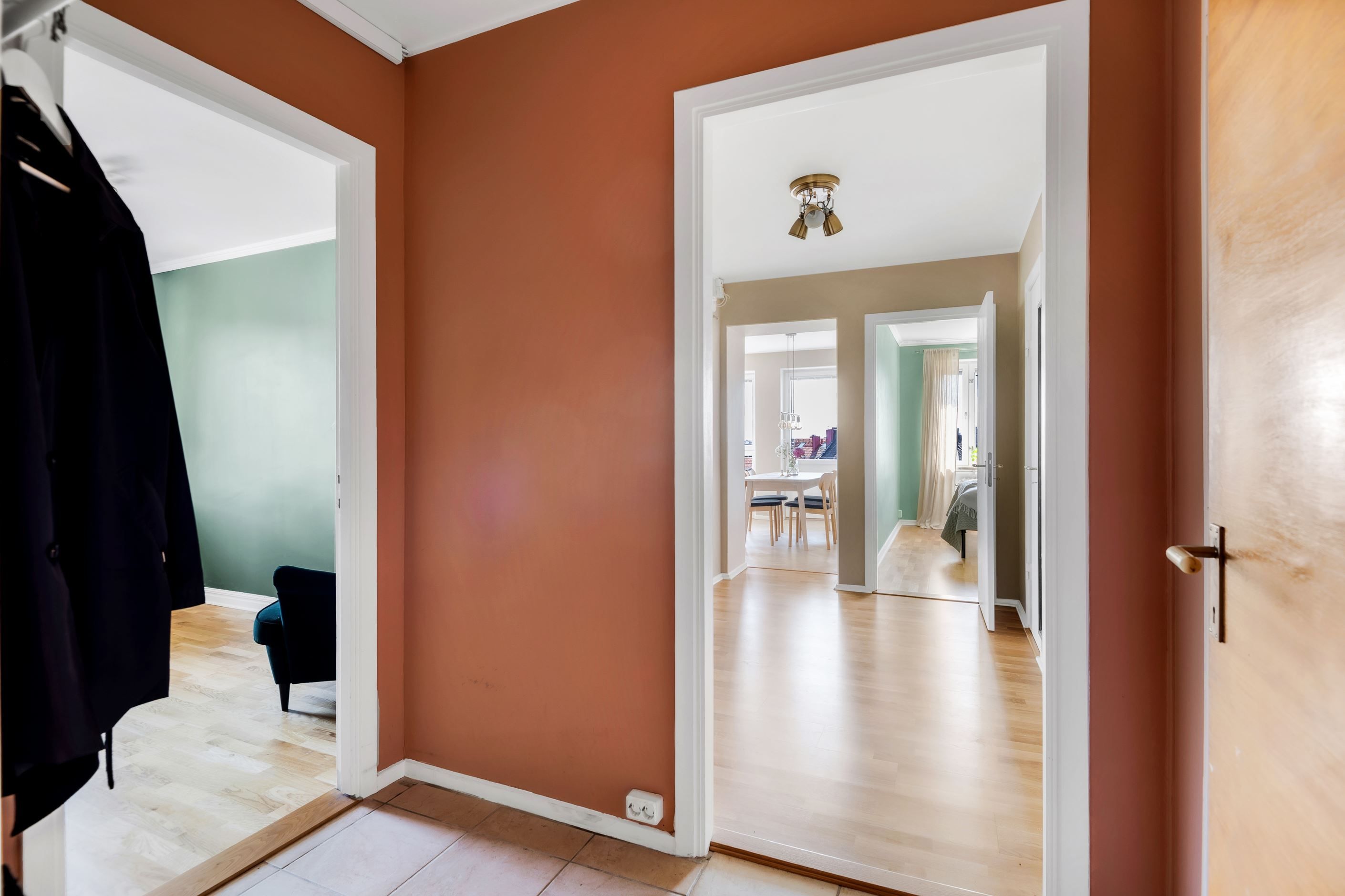 Hall med klädhängare och klinkergolv