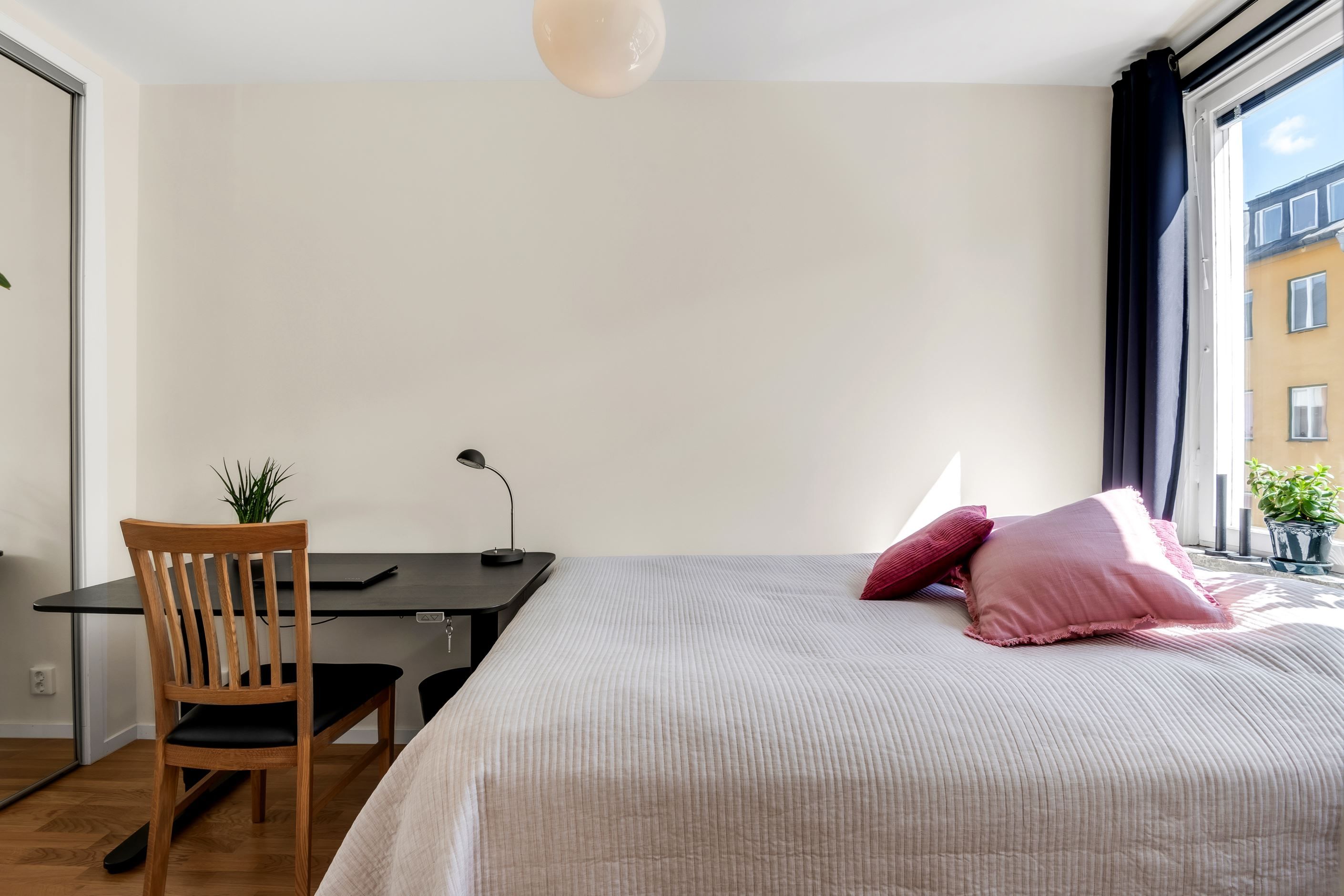 Inre del med skjutdörrsgarderob och plats för skrivbord