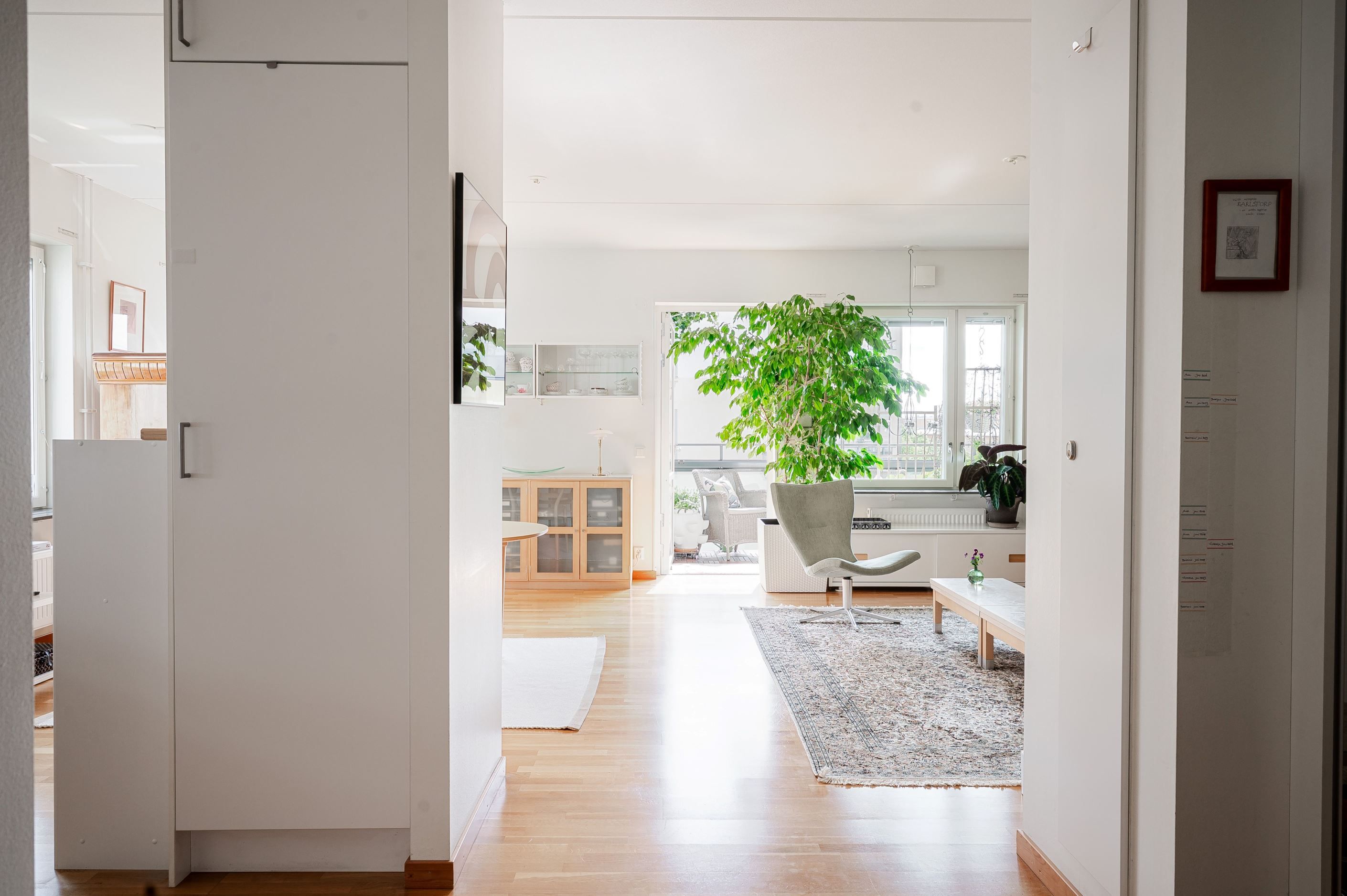 Vy från hall mot vardagsrum och utgång till balkong