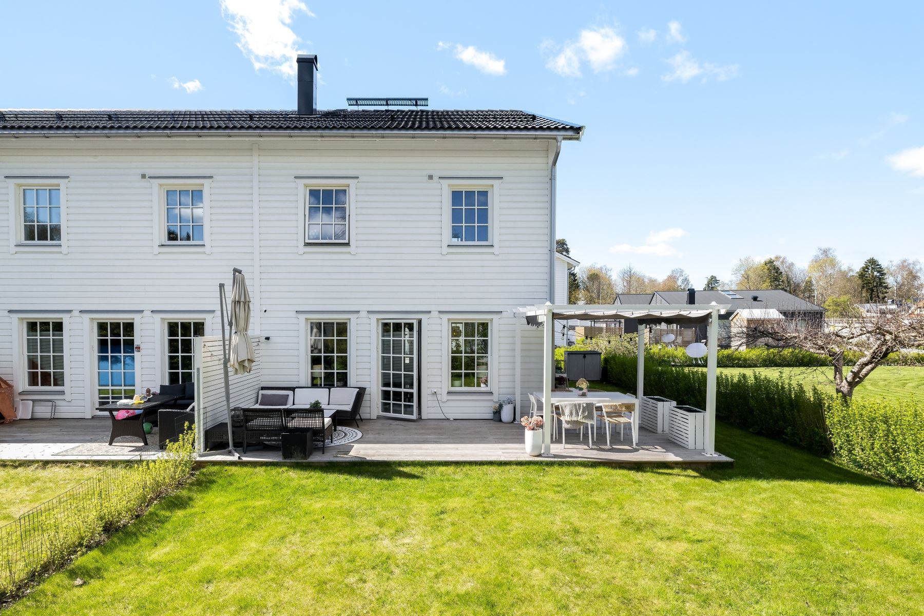 Baksida med härligt solig altan samt vacker trädgård