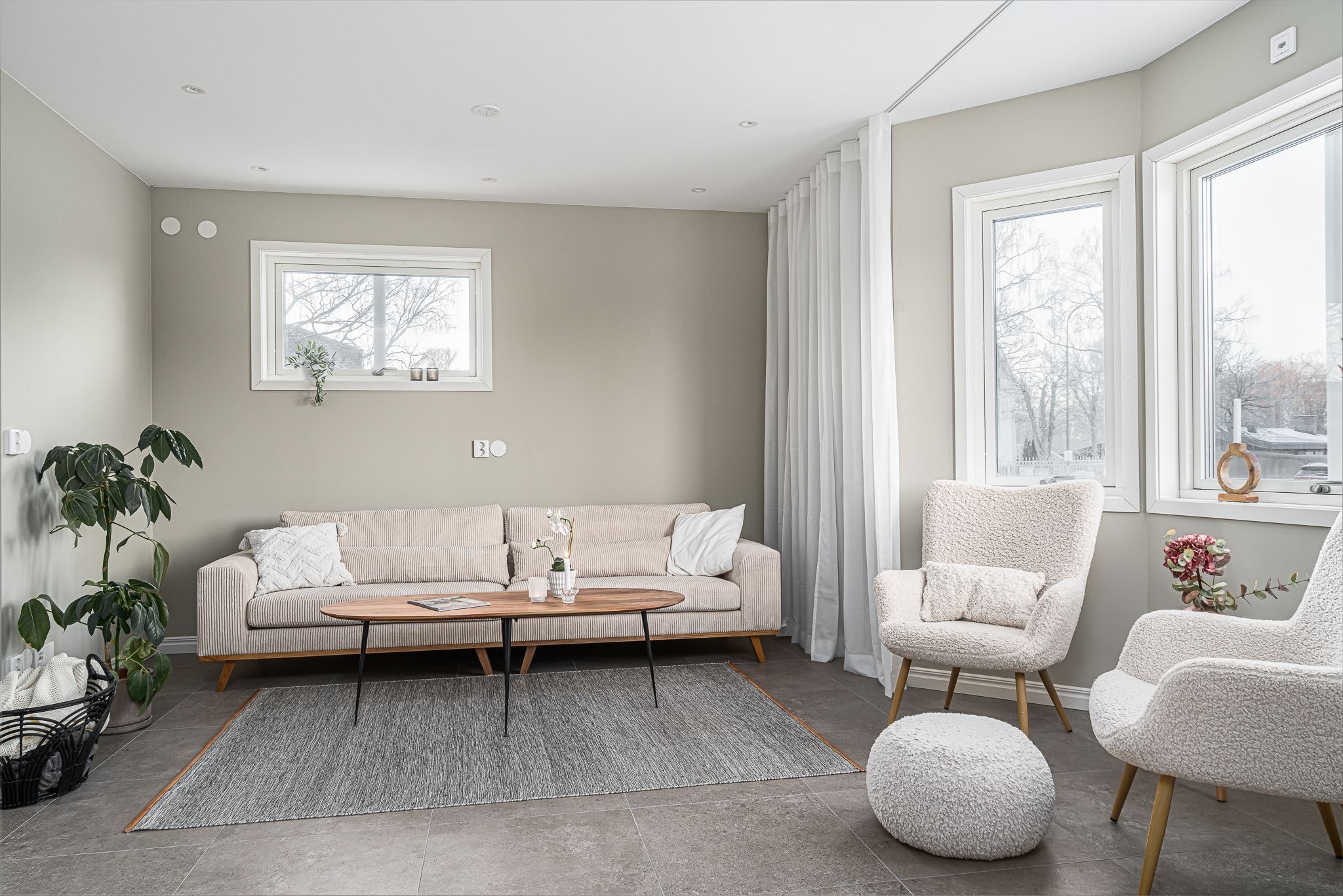 Härligt sällskapsrum med lugn beige nyans på väggarna