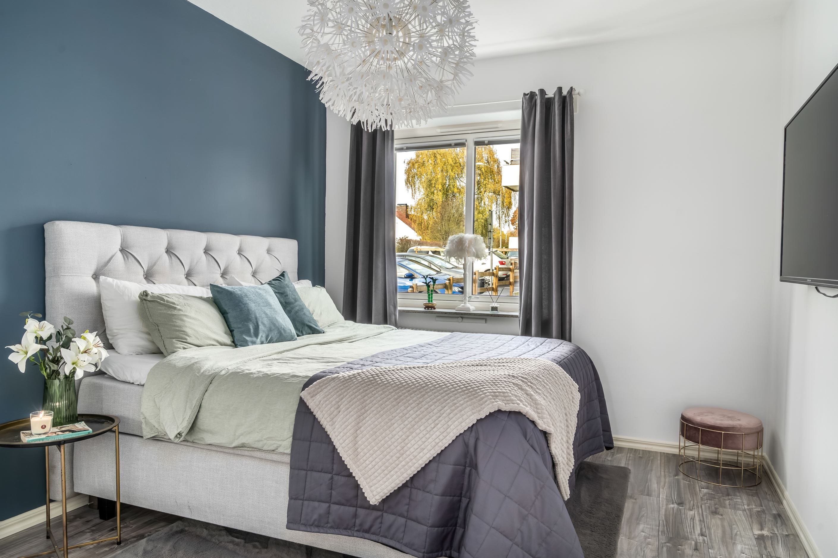 Väl tilltaget sovrum med med en fondvägg som ger en elegant känsla