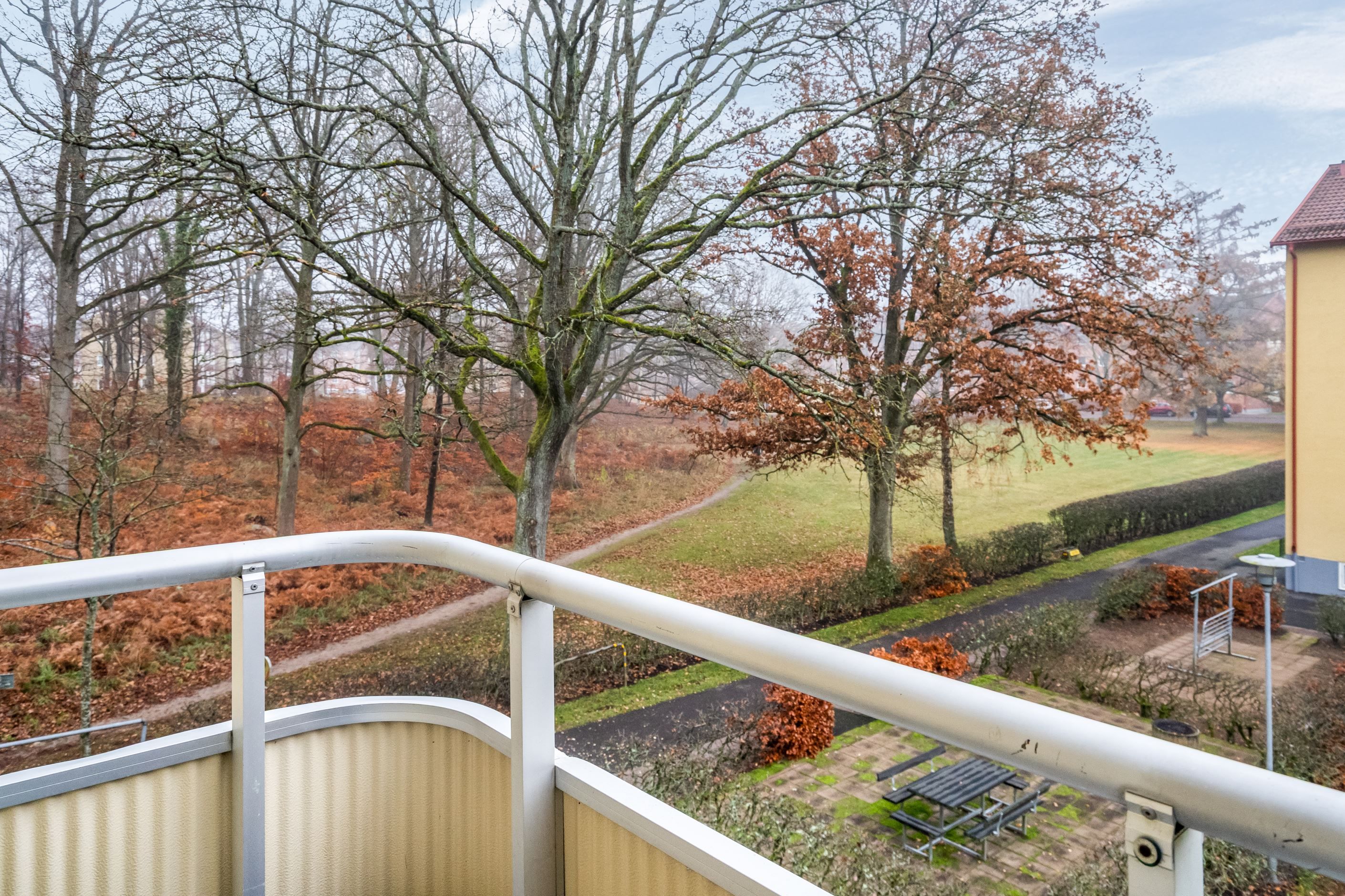 En trivsam balkongutsikt mot ett lummigt grönområde