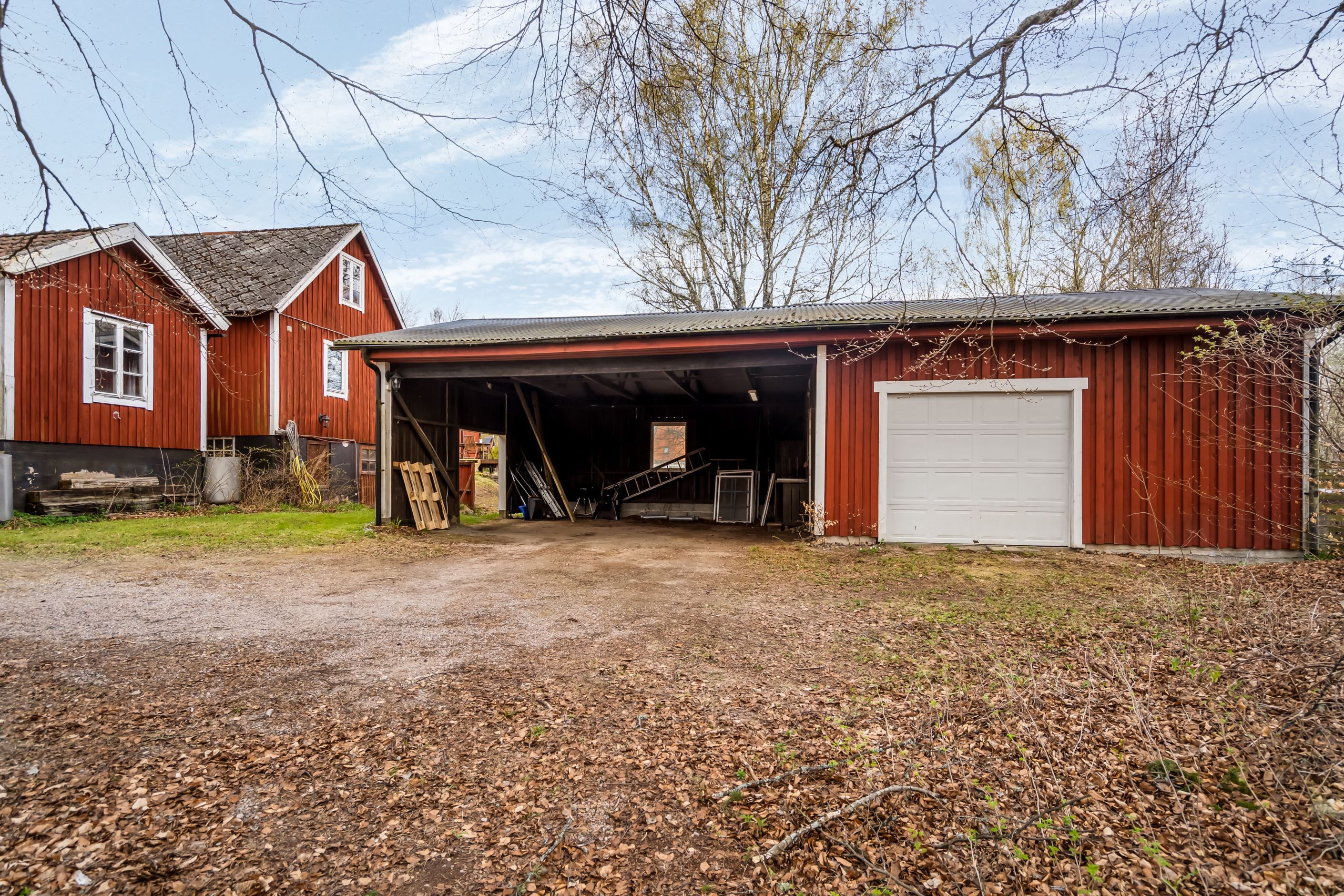 Stor carport och garage ger smidig parkering och extra förvaringsutrymme
