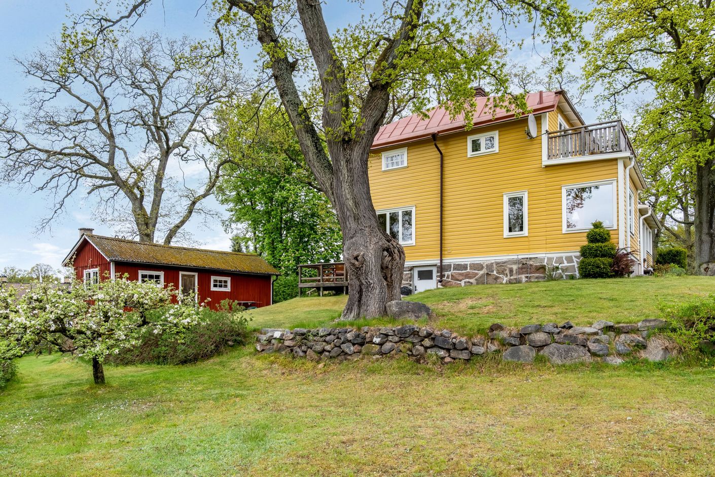 Denna gula 20-talsvilla ligger högt belägen i den stora trädgården