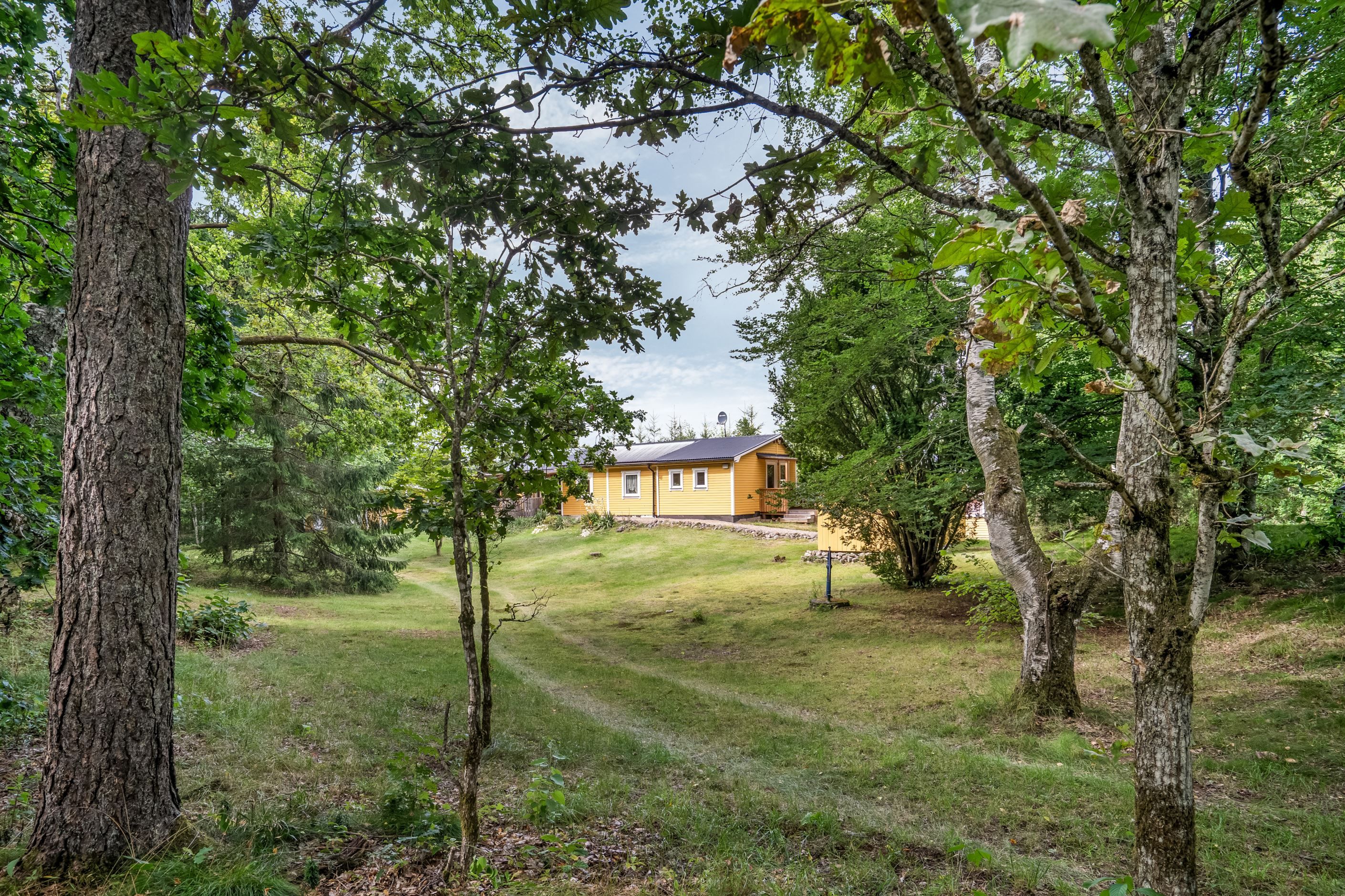 Huset ligger i en glänta med skogen som närmsta granne