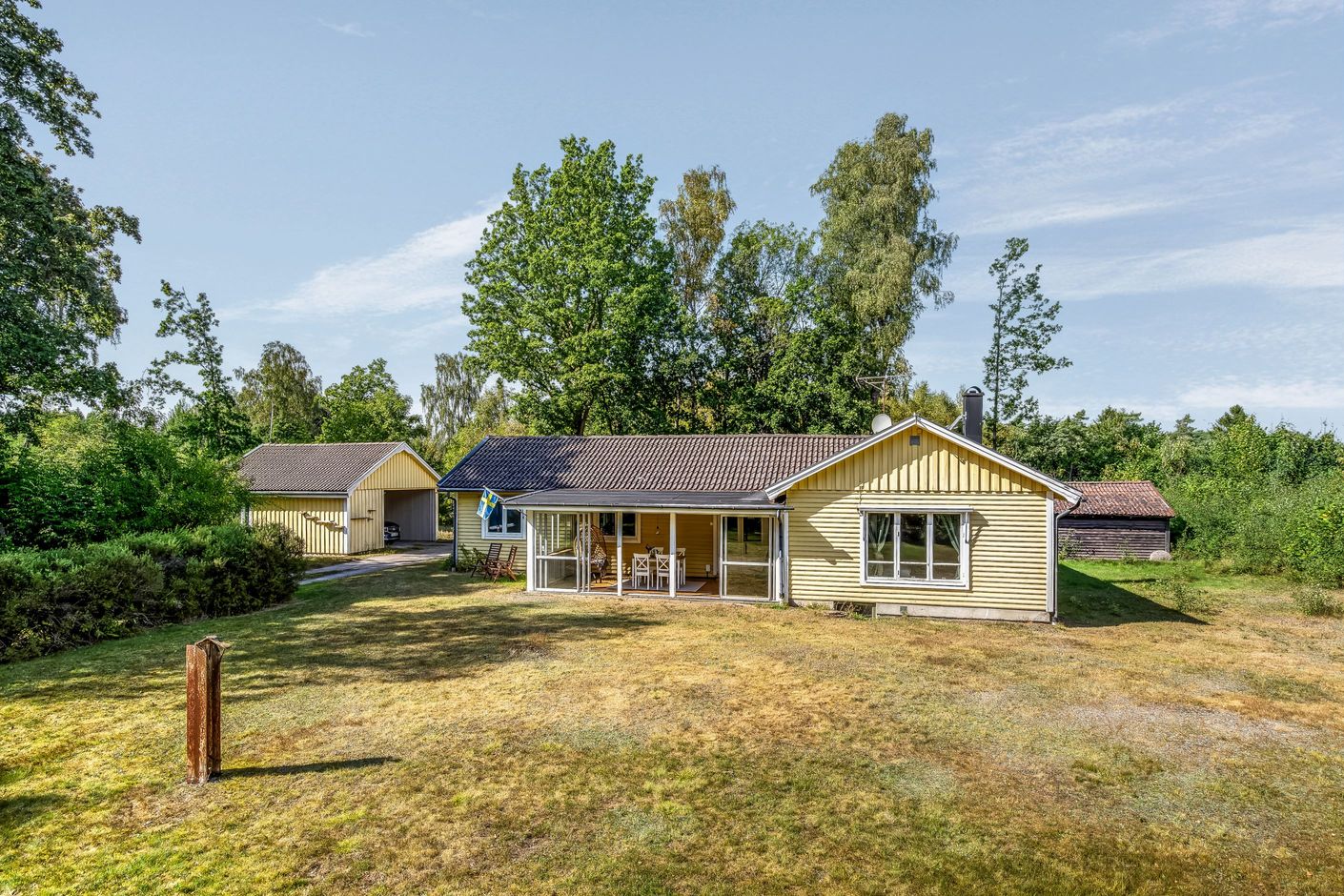 Husets framsida med stora gräsytor
