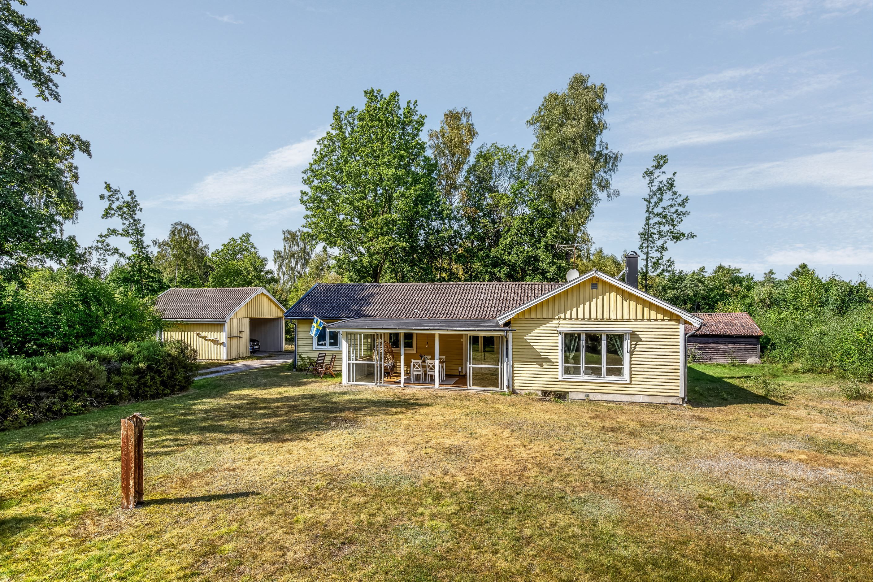 Husets framsida med stora gräsytor