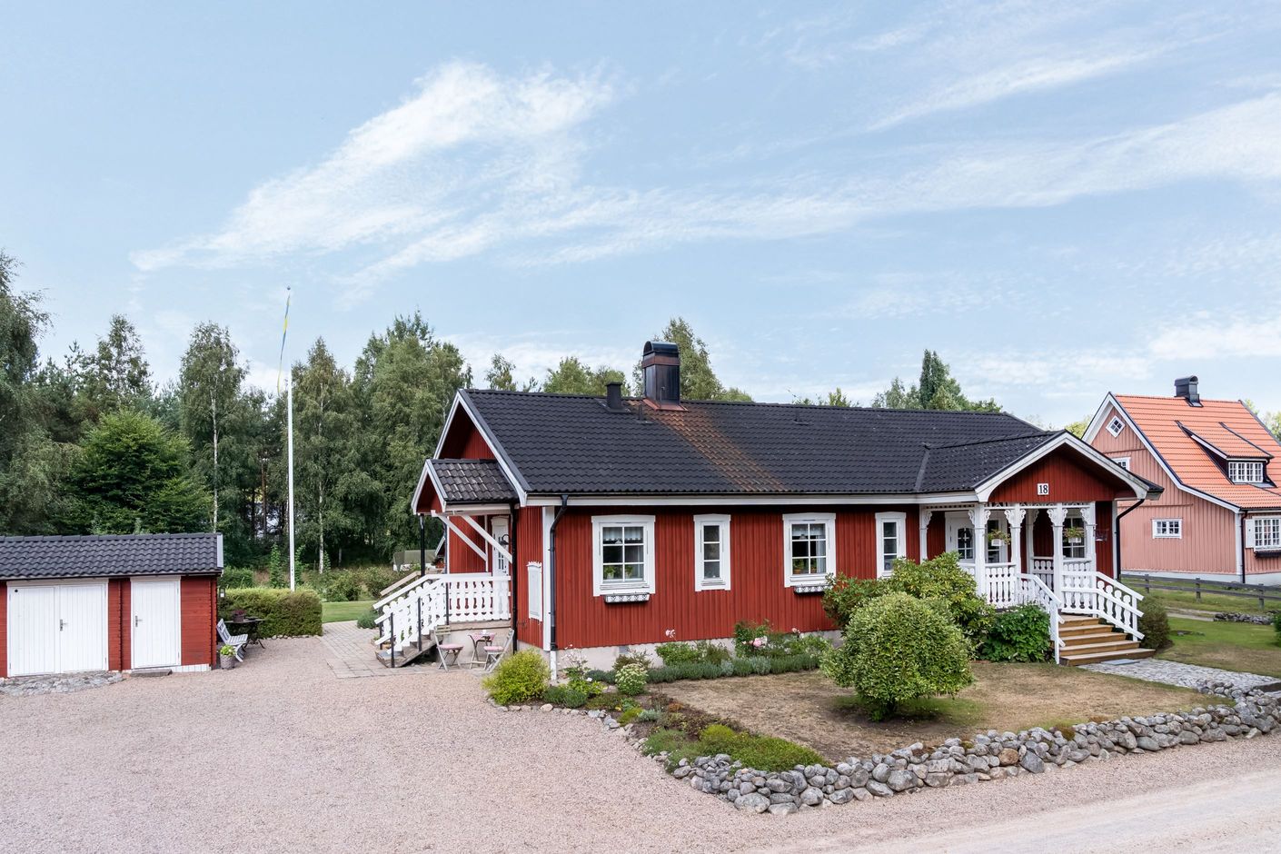 Det röda huset med vita detaljer skapar en inbjudande lantlig känsla